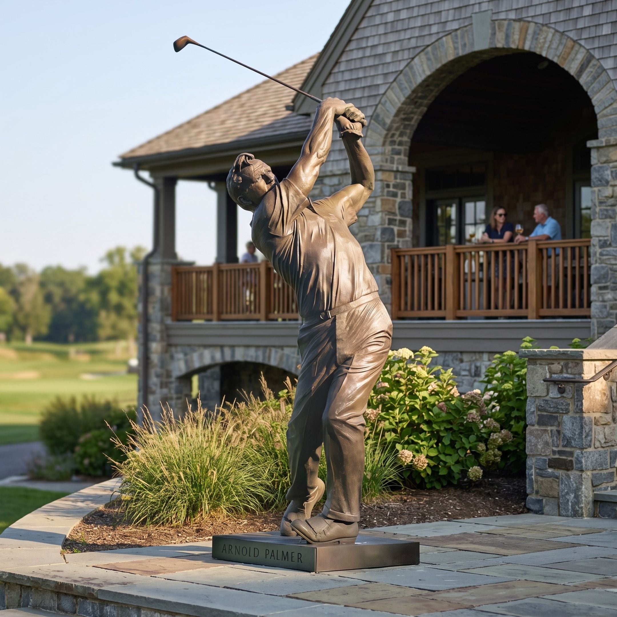 Monumental Contemporary Golfer Bronze Sculpture by Giant Sculptures at 310cm, shown mid follow-through outside a stone clubhouse with a golf course beyond.