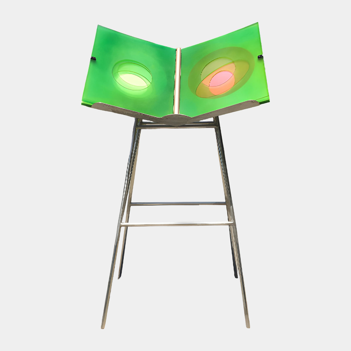 Green Open Book Acrylic Sculpture on Metal Stand - 121cm, with oval cutouts in lime and coral-pink hues, set on a splayed polished metal stand against a plain light background.