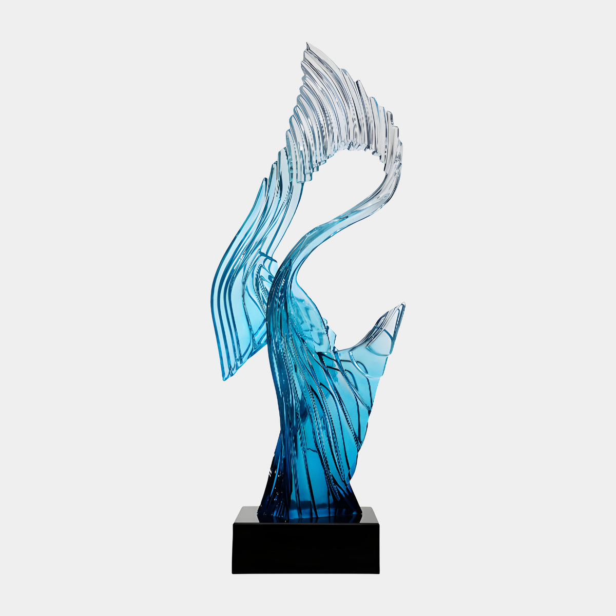 Blue Furled Ribbon Resin Sculpture on Marble, 115cm, with a ribbed wing and clear crest rising from a black square base against a plain light background.