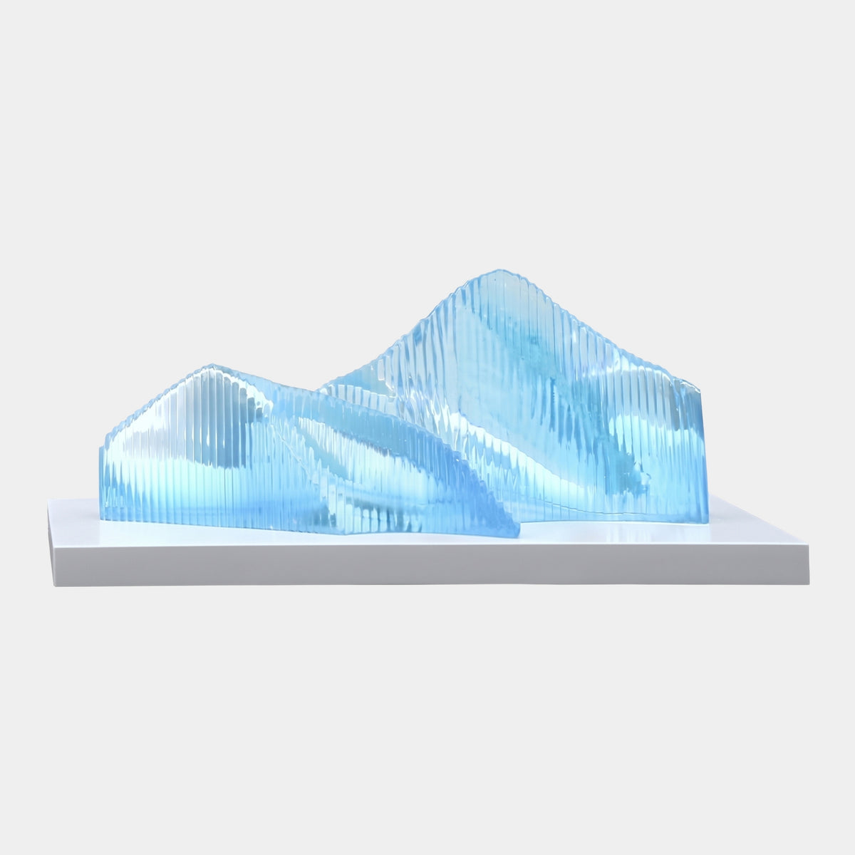 Blue Finned Overlapping Peaks Cast Resin Sculpture, 95cm, showing two ridged mountain-like peaks in translucent blue resin on a white base, set against a plain light background.