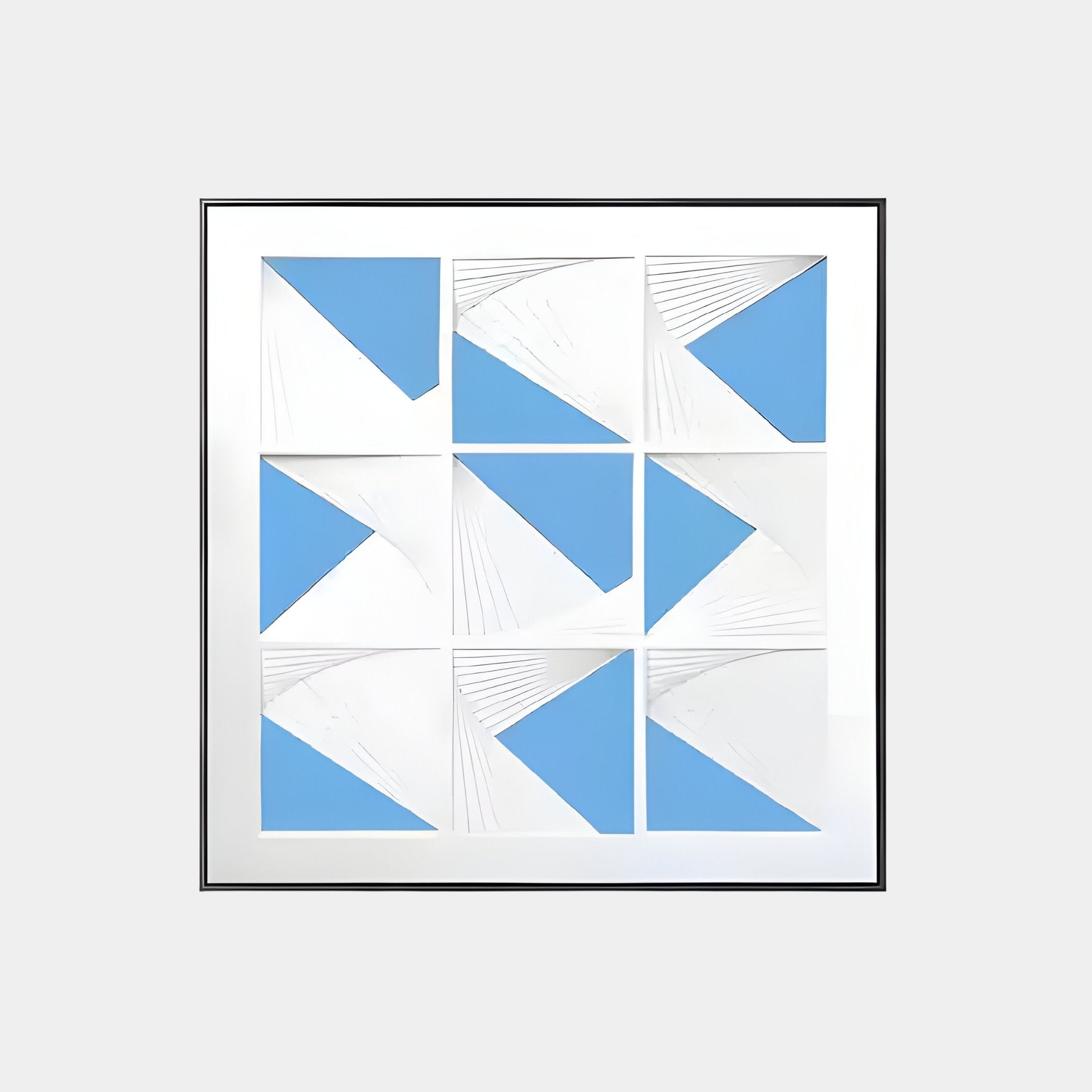 The Prismatics Blue Geometric Cardboard Carving Wall Art by Giant Sculptures features nine white squares with blue triangles and embossed lines on a light gray background, creating a striking display of modern, symmetrical artistry.