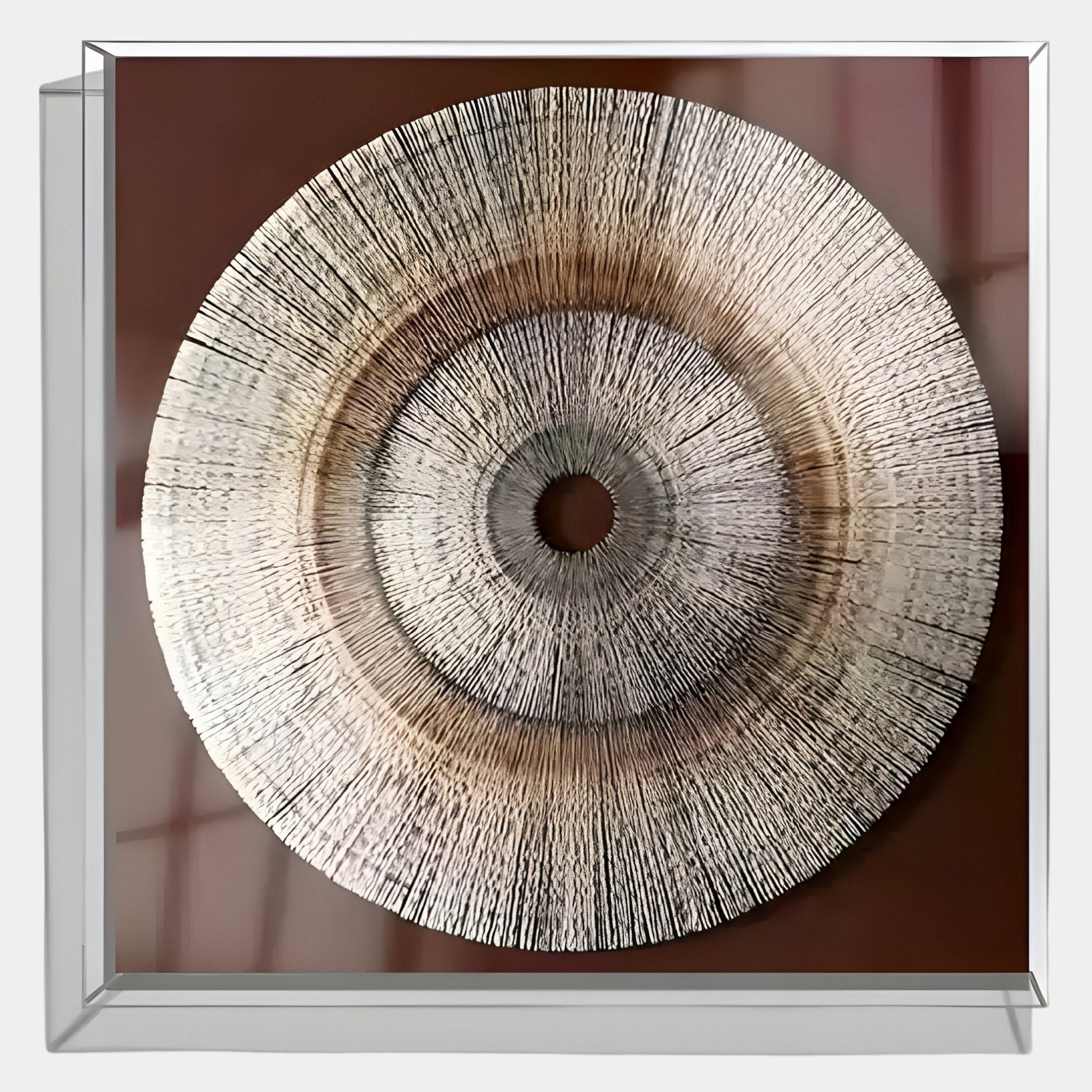 The Oculis Rustic Warmth Square Handmade 3D Paper Wall Art by Giant Sculptures features a round, textured design with radiating lines and a central hole, set in a clear-framed shadow box against a brown backdrop.