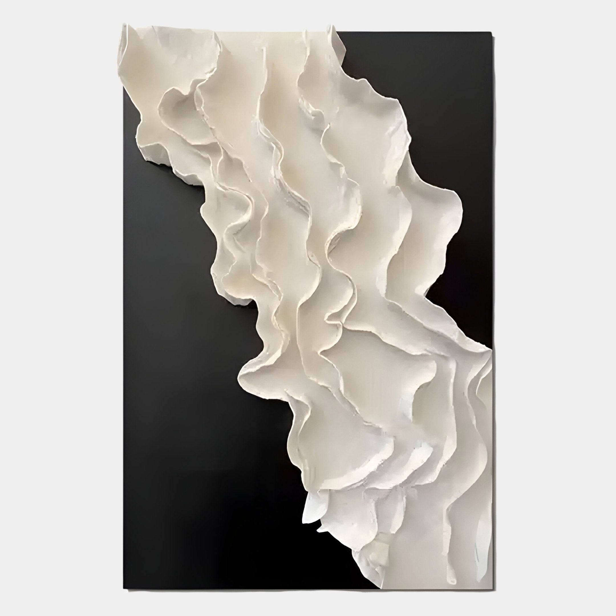 The Stratura IV Black & White Layered Paper Canvas Wall Art by Giant Sculptures features white, ruffled sculptural forms diagonally cascading over a black background, creating a striking monochrome contrast with dynamic texture and depth.