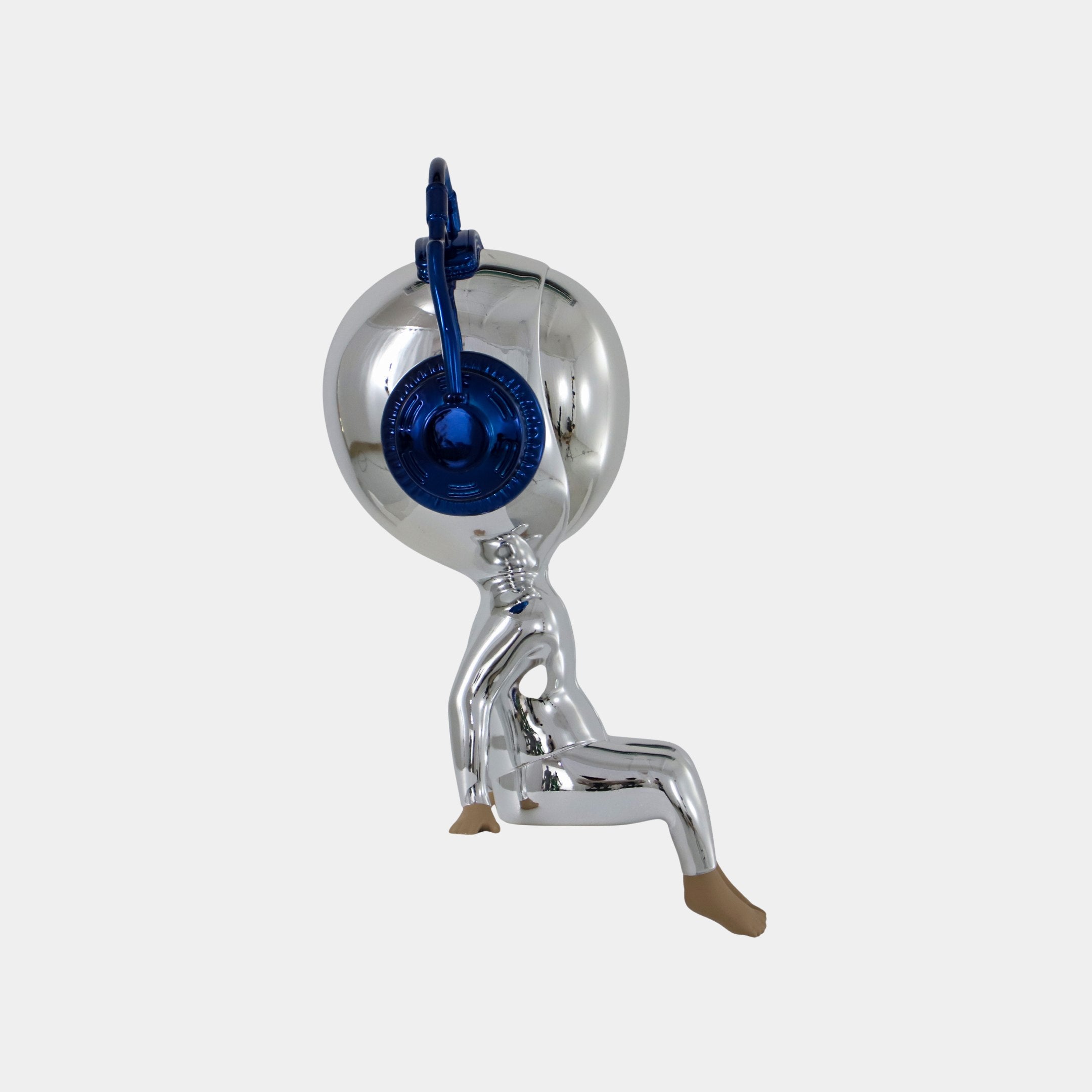 The Giant Sculptures Midnight Chrome Alien Beats Figure - 55cm features a reclining pose with bent legs and a beige hand for support. Its oversized mirrored visor has a blue circle, creating a striking, futuristic accent against a plain white backdrop.