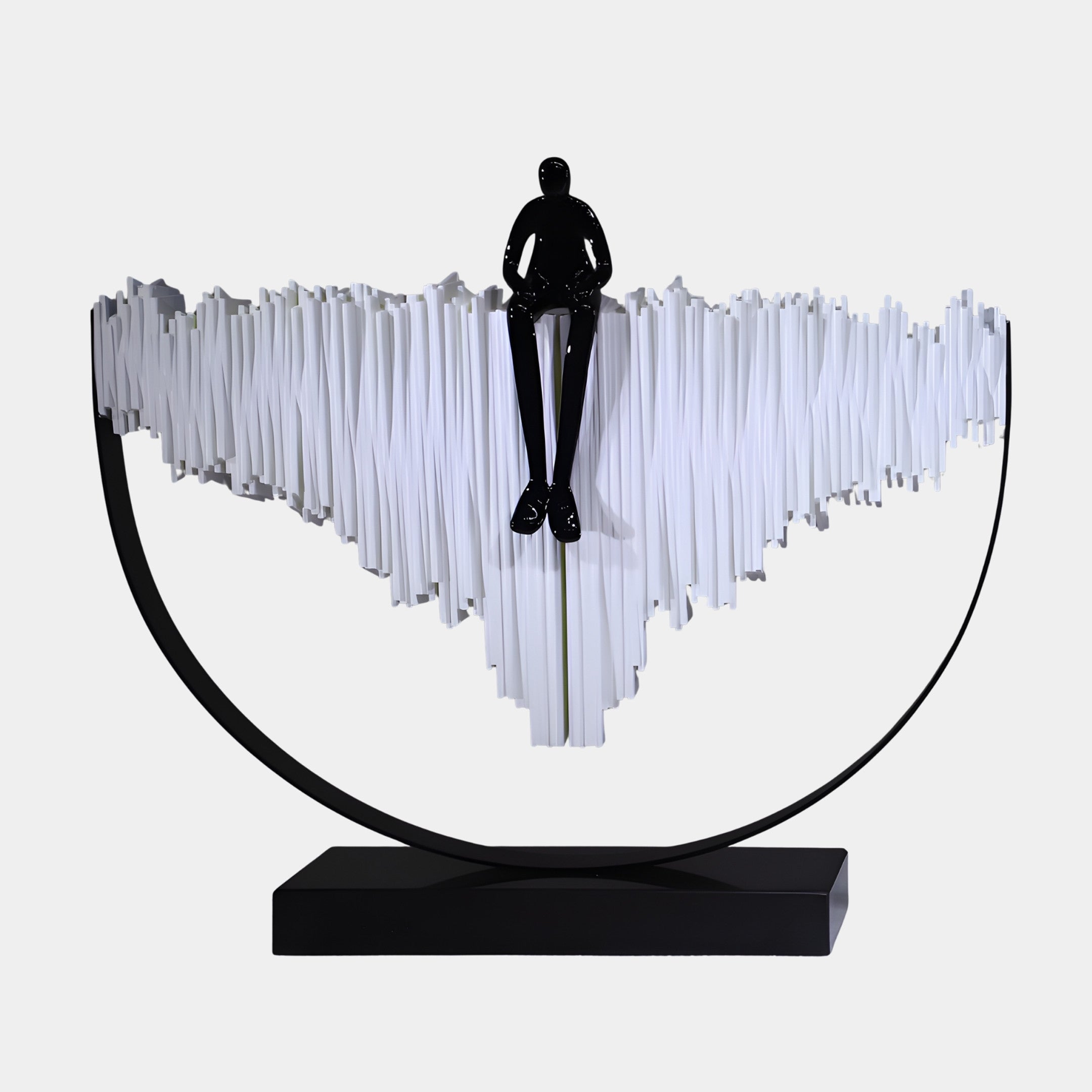 Black & White Seated Figure in Halo Ring Sculpture by Giant Sculptures, glossy black figure perched on a jagged white ridge within a black halo frame.