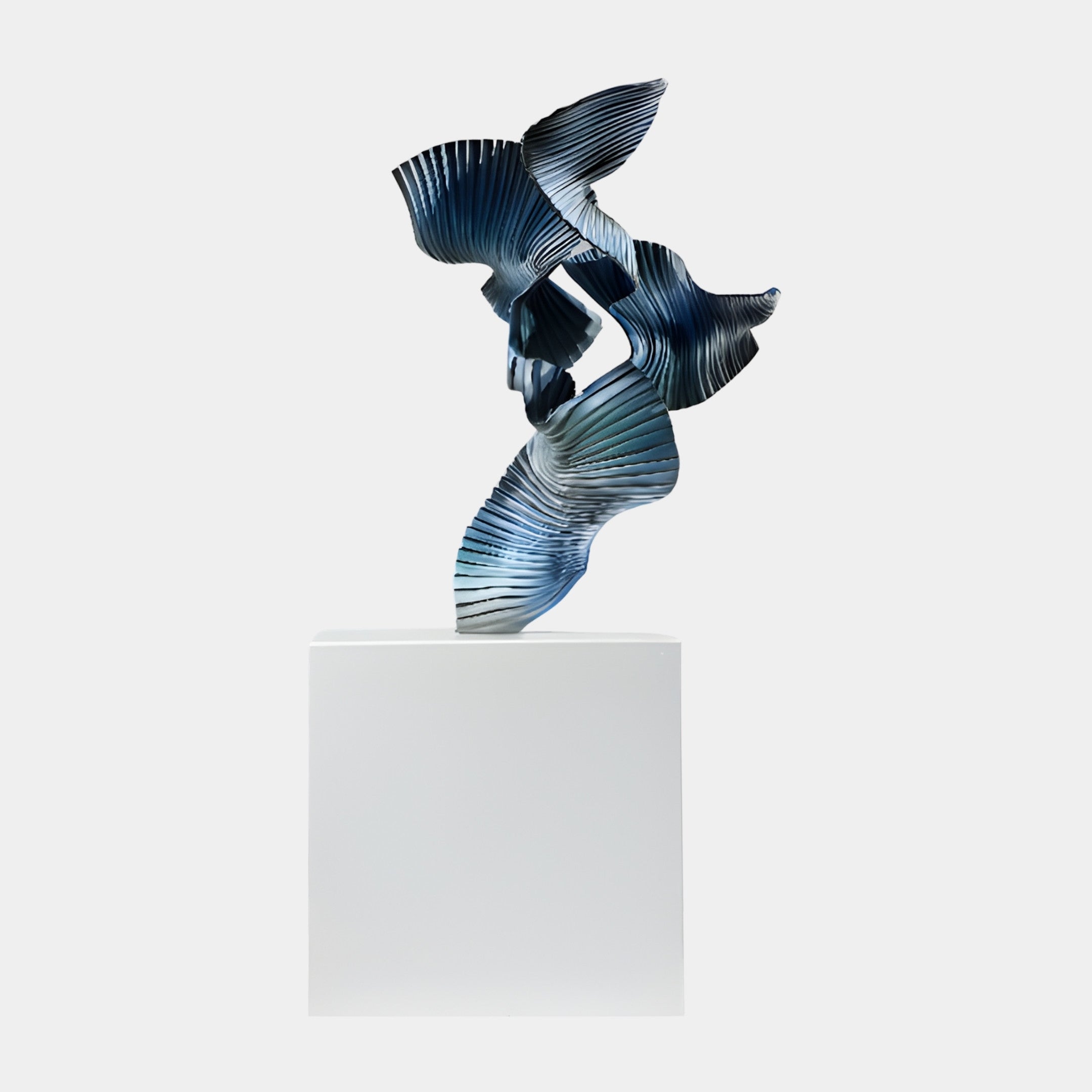 Blue Abstract Flying Bird Sculpture by Giant Sculptures, a 3D-printed resin form with pleated ribbed surfaces twisting upward, displayed on a white pedestal.