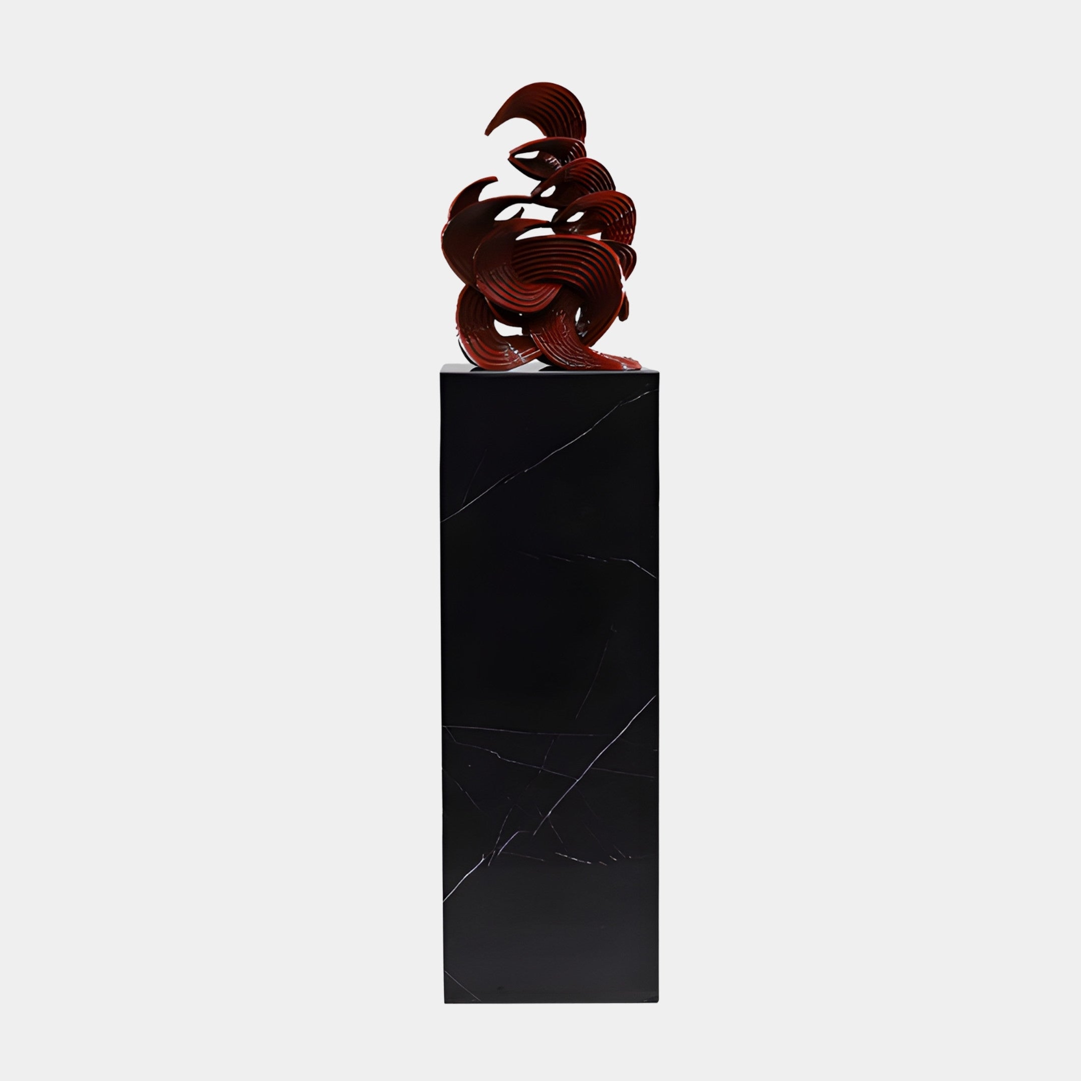 Red Abstract Knot on Black Base Sculpture by Giant Sculptures, featuring a glossy ribbed swirling form in deep red atop a tall black marble plinth.