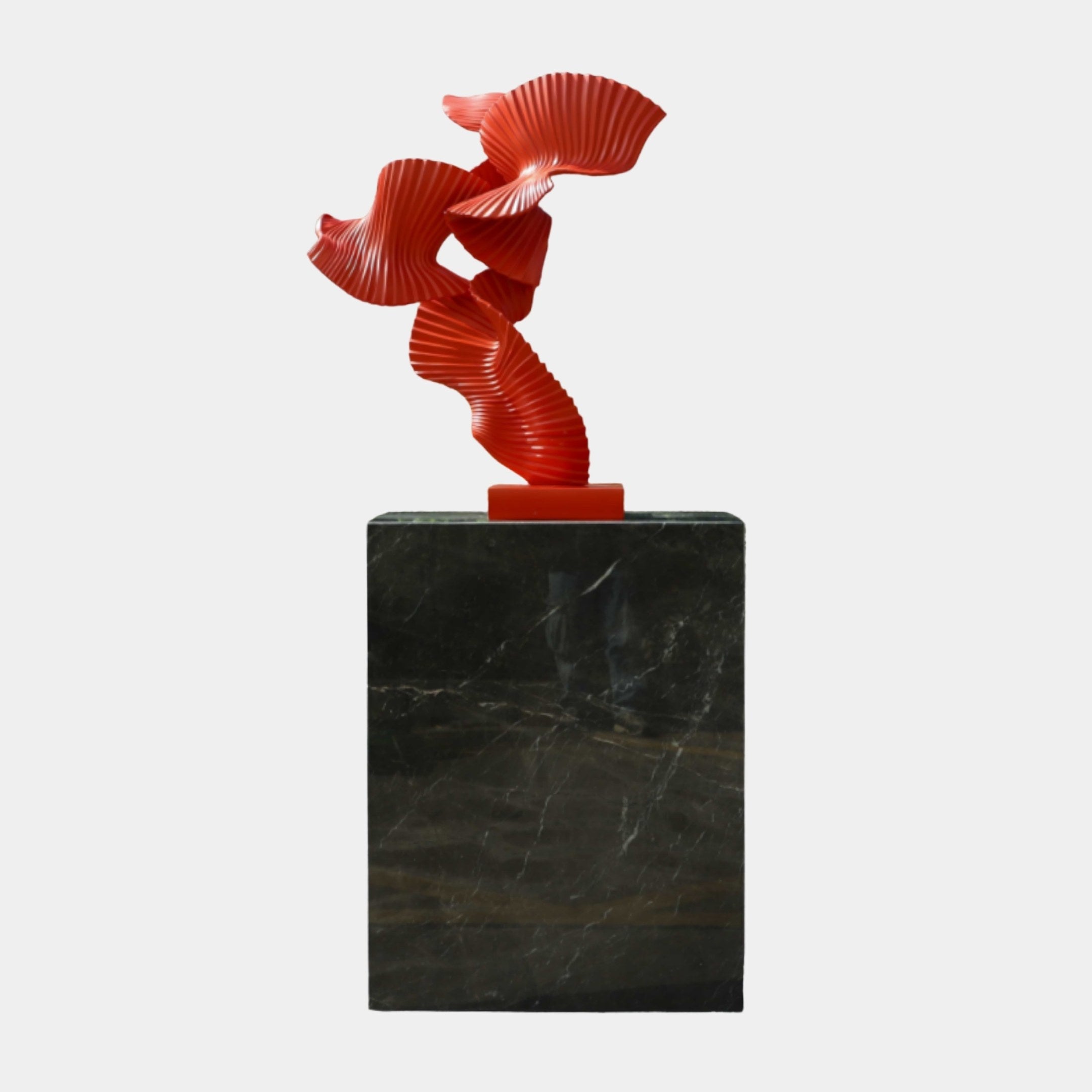 Red Abstract Goldfish on Black Base Sculpture by Giant Sculptures, featuring pleated fan-like resin forms curling upward on a tall dark marble plinth.