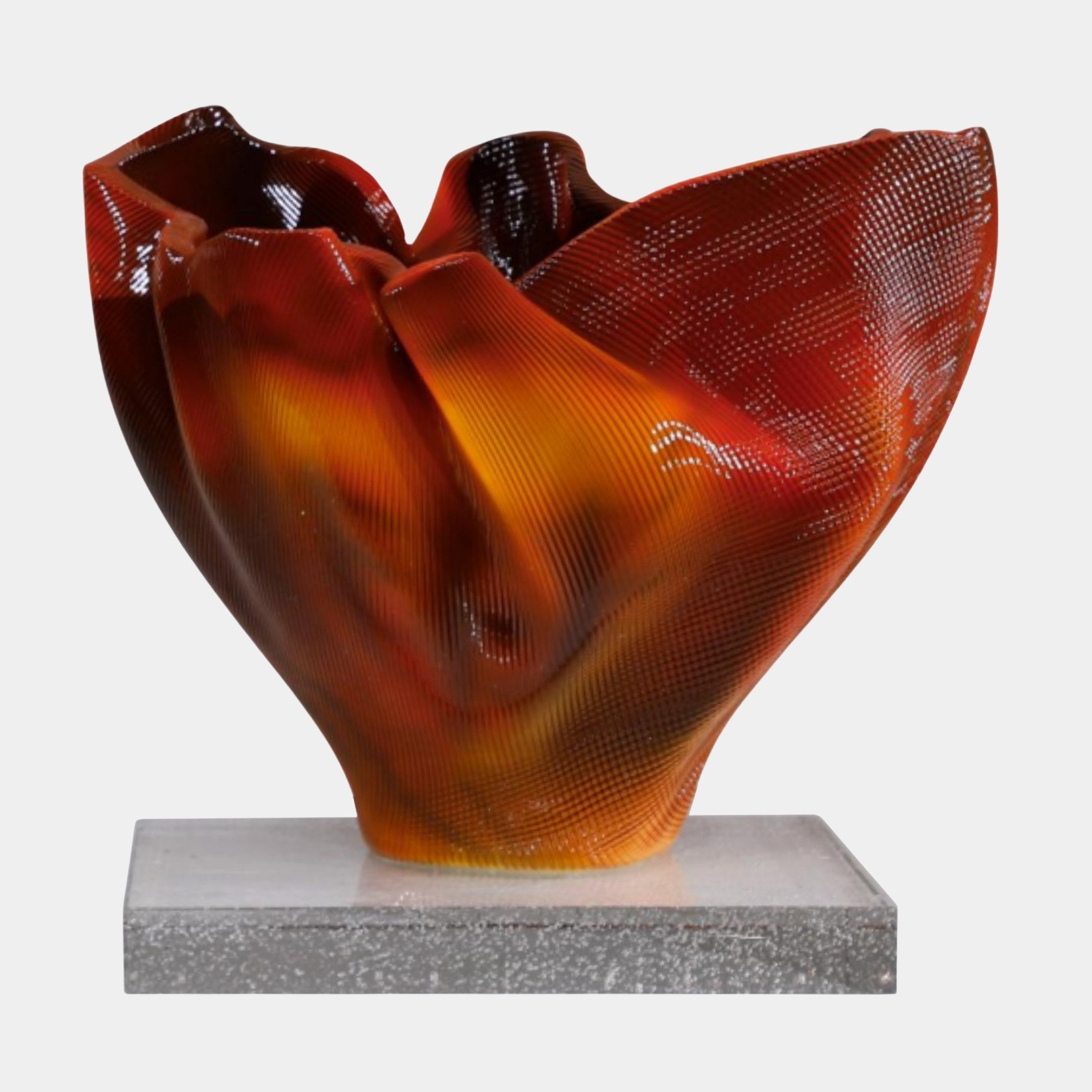 Giant Sculptures Red Amber Glass Abstract Flame Bowl with ribbed translucent walls in deep red and glowing amber, set on a grey base against white.