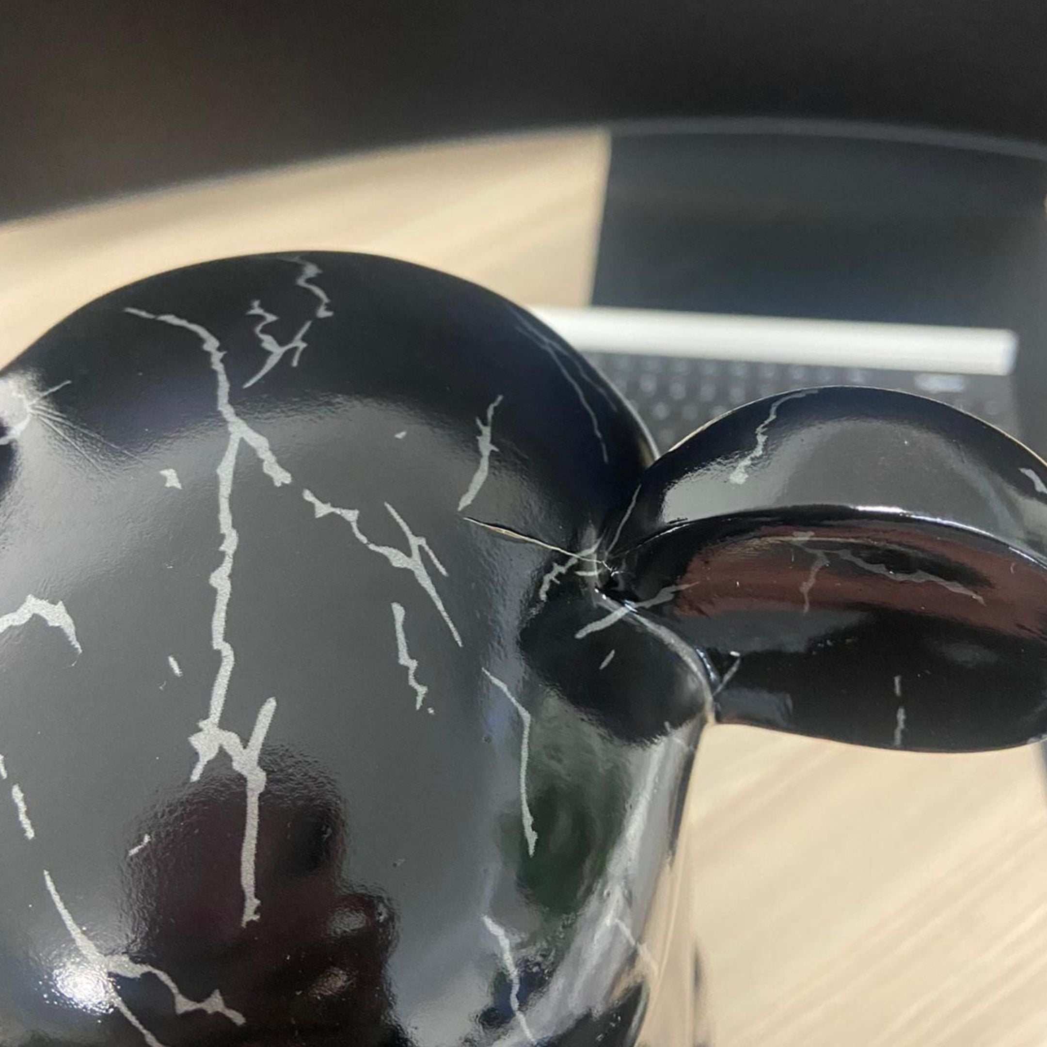 Close-up of the Giant Sculptures Black Stone Bear Sculpture 50cm showing the glossy black resin finish with white veining and a visible cut on the head.