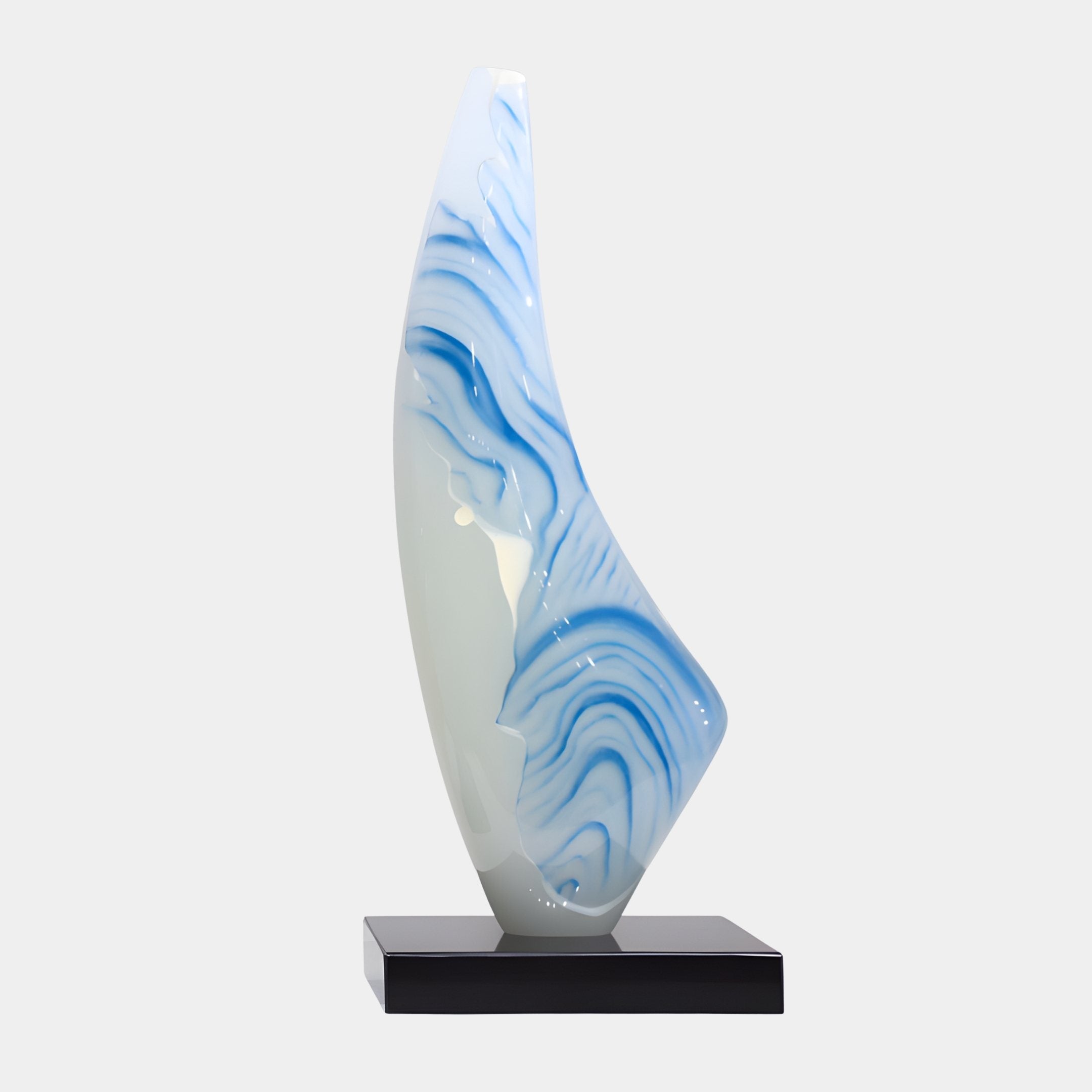 Ocean Flame Blue Abstract Jade Sculpture in pearlescent white with deep blue painterly wave swirls, rising in a tapering flame form on a black plinth.
