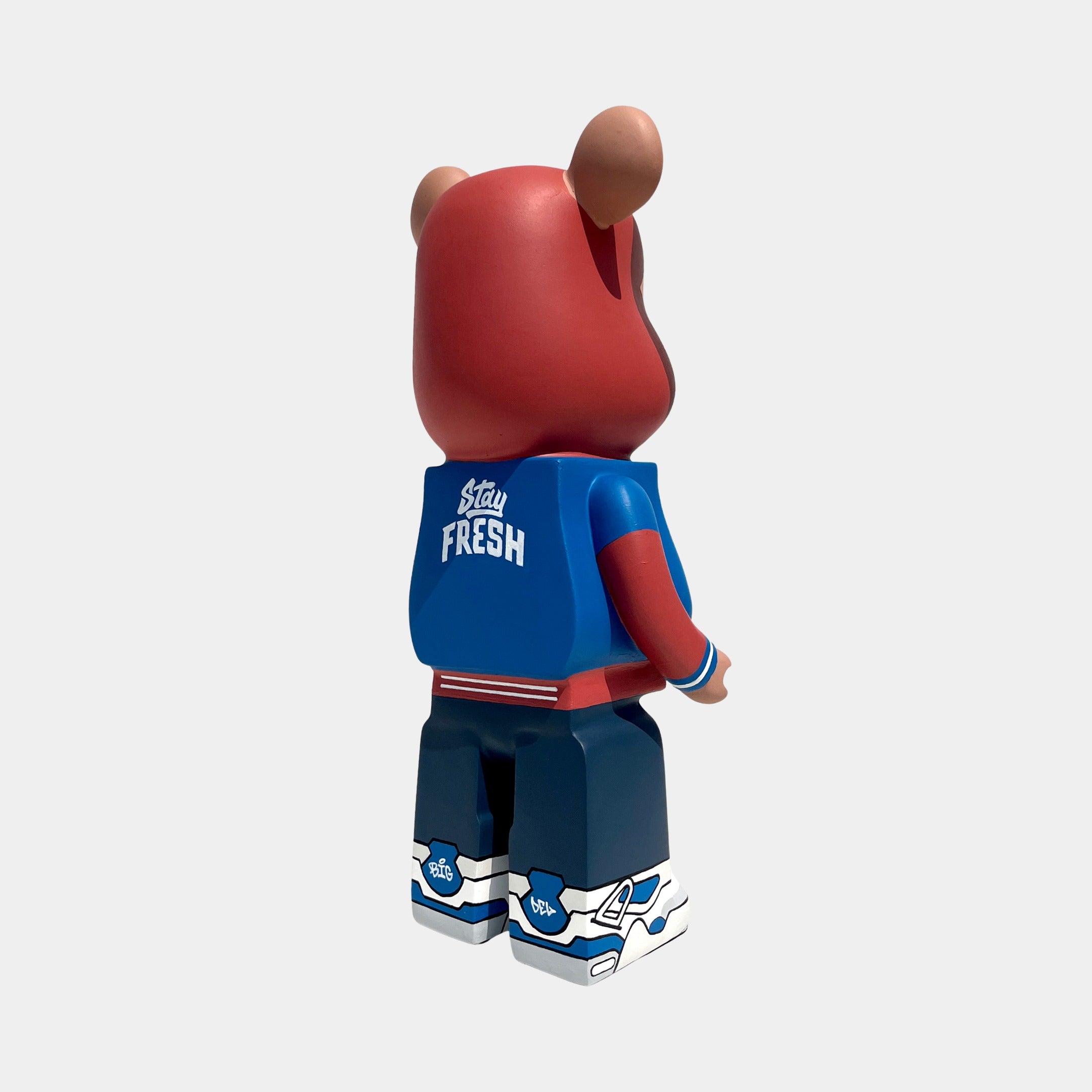 The Fresh Grizz Bear Sculpture - 135cm by Giant Sculptures is a limited edition toy bear in streetwear, sporting a blue varsity jacket with "Stay FRESH" on the back, blue pants, and white sneakers—all against a plain light background.