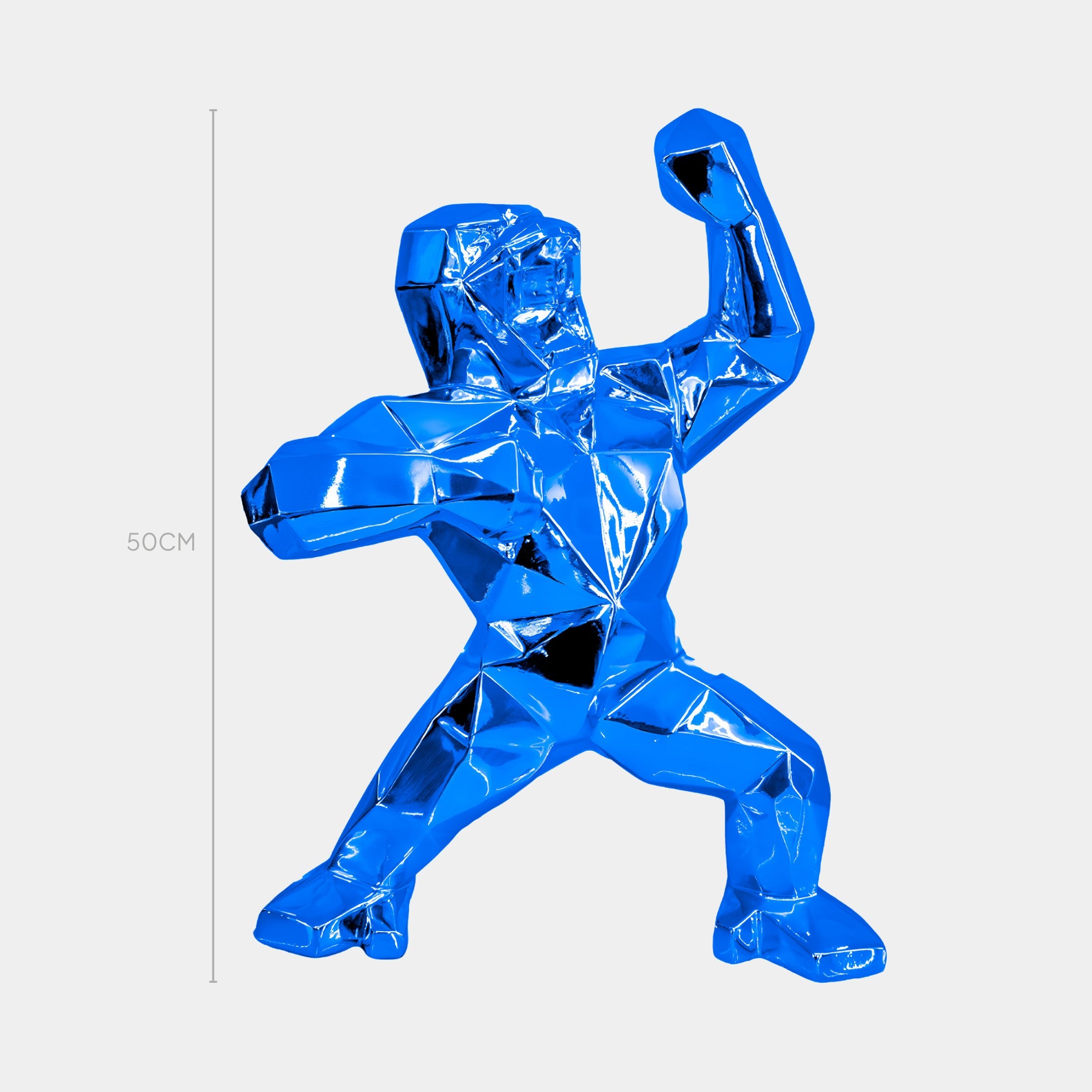 The Sapphire Blue Gorilla Sculpture by Giant Sculptures features an abstract, dynamic design with a raised fist, in vibrant blue. Resembling a person frozen in action, it stands 50cm tall against a plain light gray background.