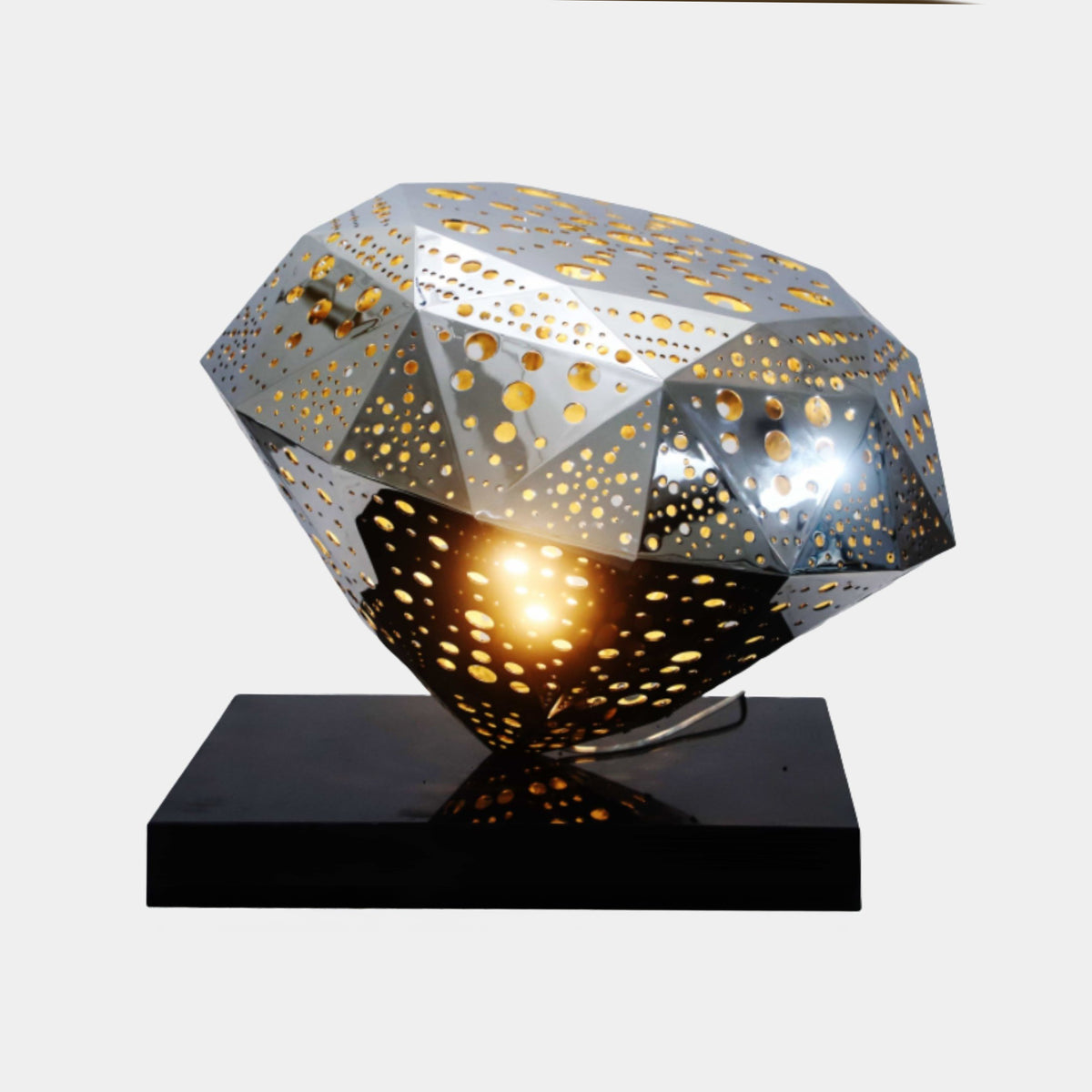 Silver Faceted Polyhedron Stainless Steel Sculpture, 78cm, perforated diamond form lit from within on a black base against a plain light background.