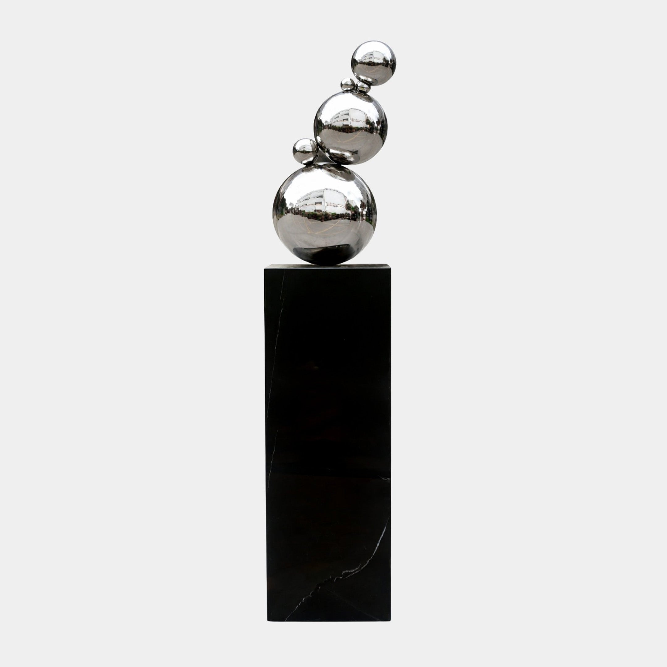 Silver Spheres Stainless Steel Sculpture, 148cm, stacked polished spheres on a black plinth, Giant Sculptures, plain light grey background.