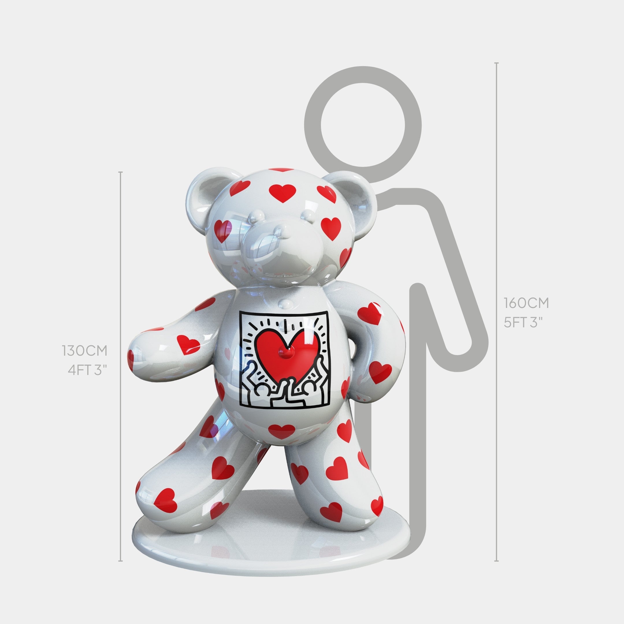 The Gacko Keith Haring White Bear Sculpture by Giant Sculptures is a 130cm glossy white bear adorned with red hearts and a cartoon heart on its chest. It stands on a round base and is shown beside a grey human outline for scale.