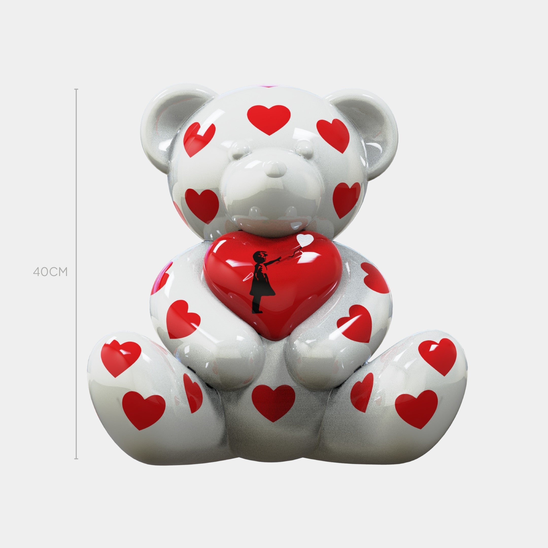The Gacko Banksy Love Bear Sculpture by Giant Sculptures stands 40cm tall, features a white bear covered in red hearts, and holds a large heart with a girl silhouette—bringing street-art charm to pop art style. Shown against a plain background.