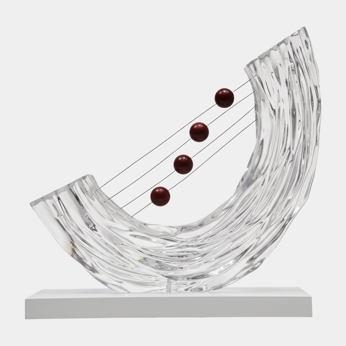 Clear Oxblood Sphere Sweep Resin Sculpture, 55cm, a rippled clear resin curve with four oxblood red spheres strung on wires at rising heights, on a white base against a plain background.