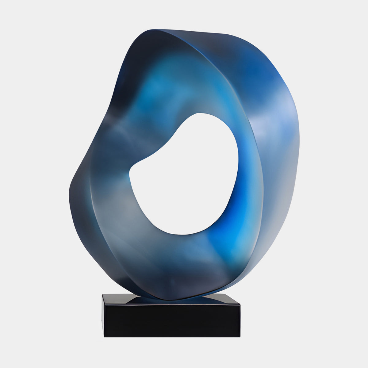 Blue Frosted Pierced Ring Resin Sculpture, 58cm, a twisted ring with a soft central opening in navy, vivid blue, and misty grey-blue tones, set on a black marble block against a plain white background.