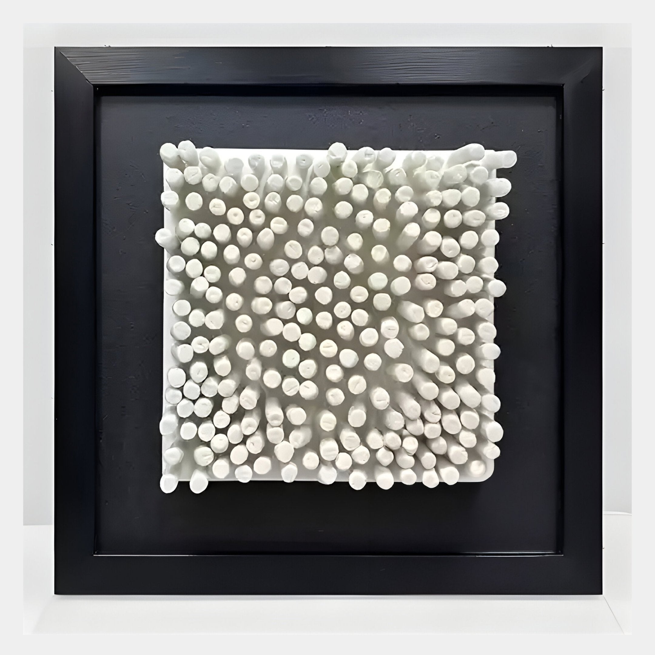 The Harmonia 3D Ceramic Grid Wall Sculpture by Giant Sculptures features white ceramic rods of varying lengths on a central square panel, set in a black frame and acrylic box—an eye-catching, modern wall art piece.