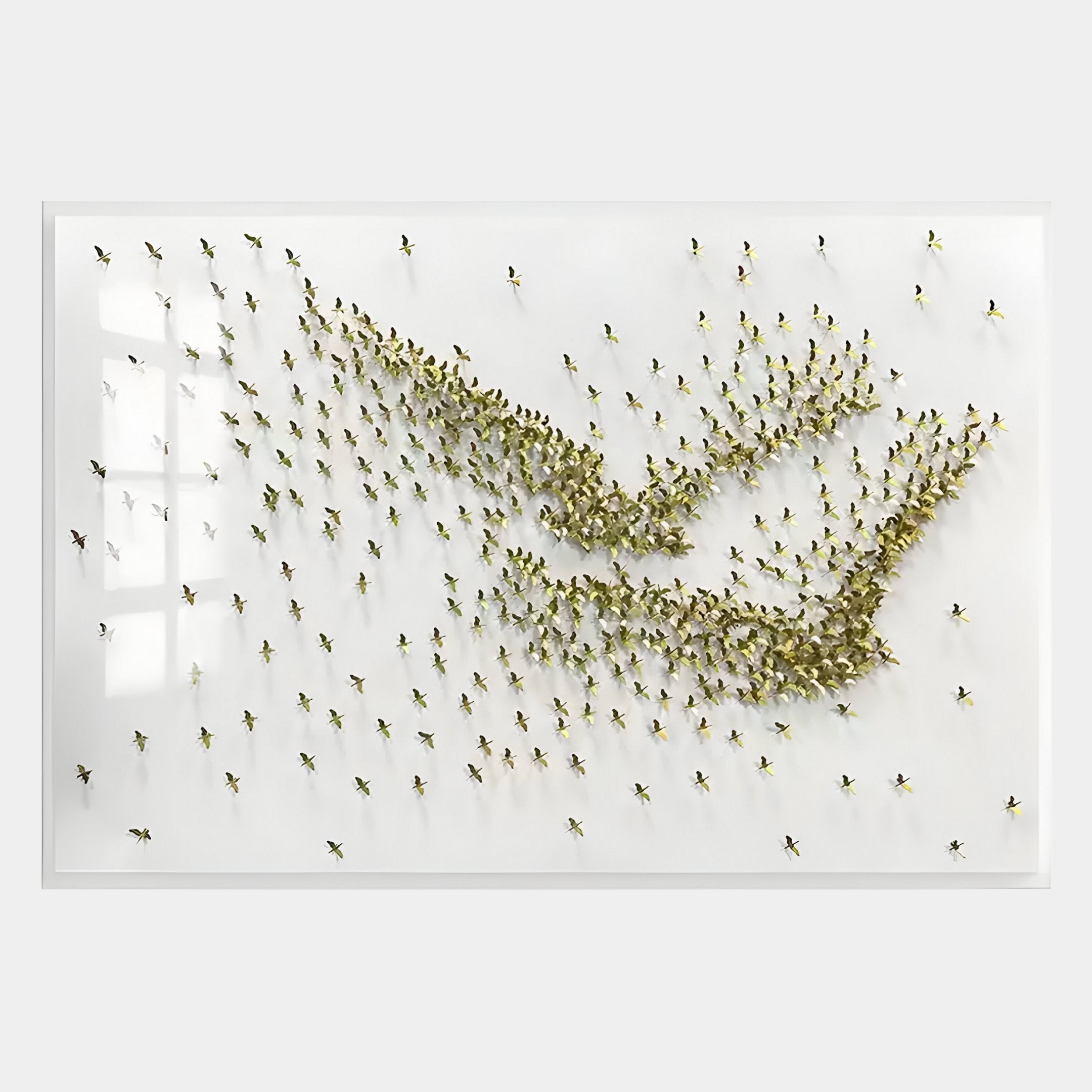The Flock Golden Flight Sculpture Metal 3D Wall Art by Giant Sculptures features gold-hued human figurines swirling on a white background, creating the illusion of movement and a flock in flight.