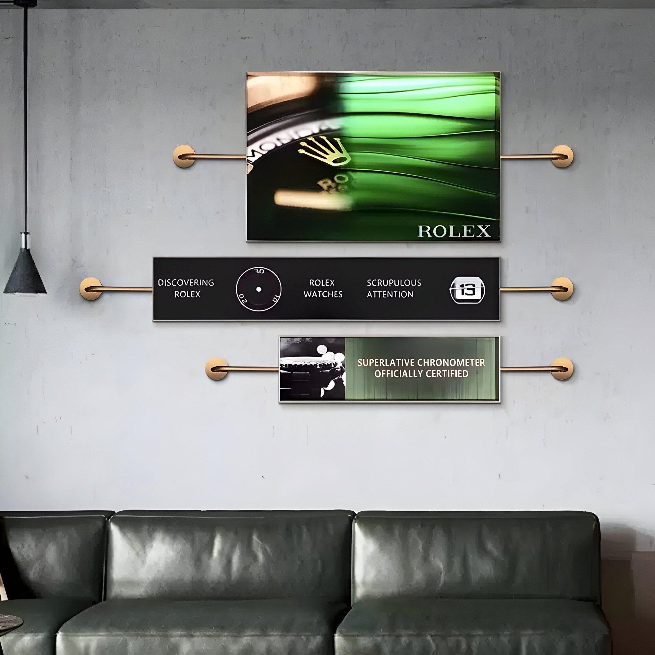 Above the green leather sofa, the wall display presents three mounted Visario Rolex Inspired Luxury Metal Wall Art pieces by Giant Sculptures, featuring a Rolex watch face and logo with phrases like Superlative Chronometer.