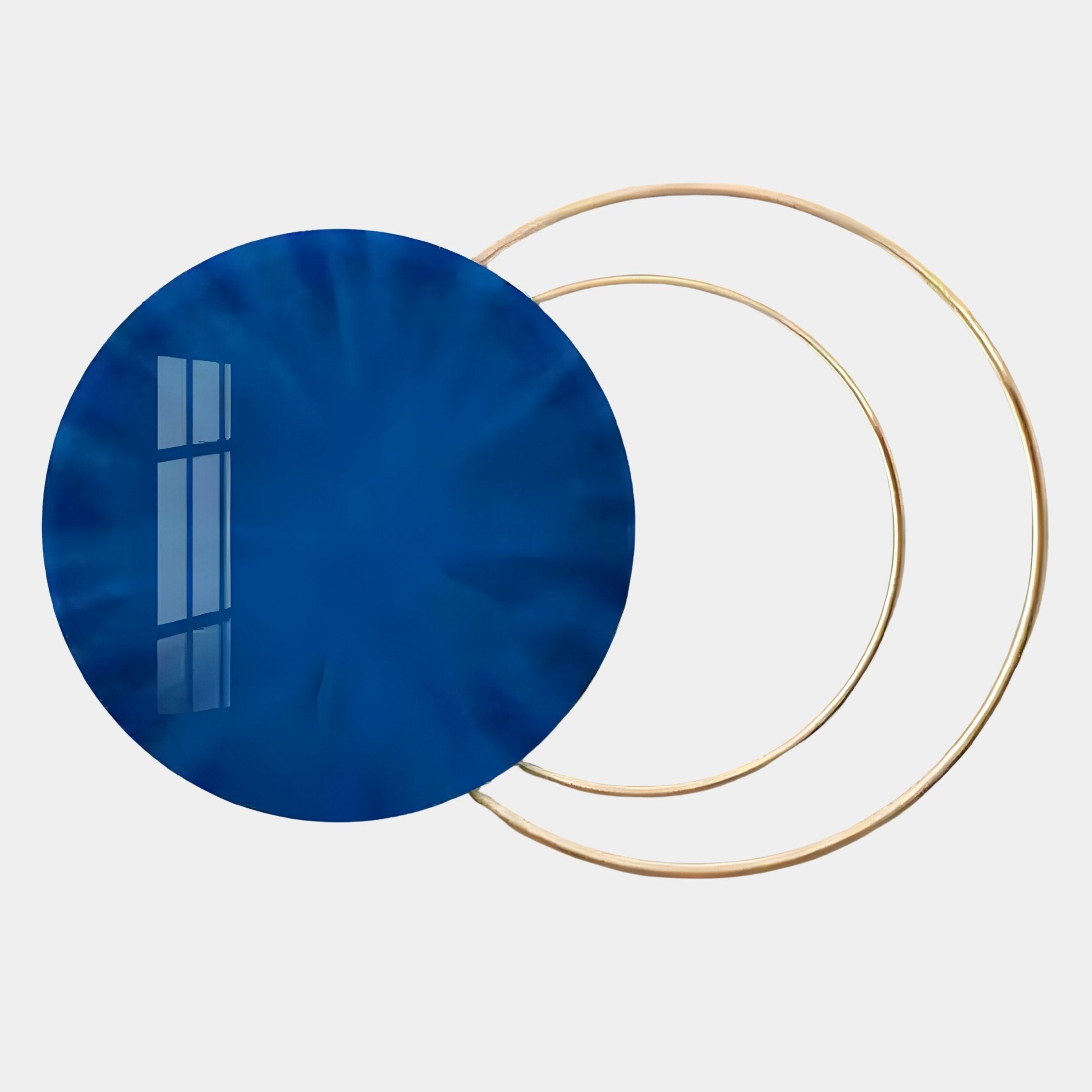 The Eclipse Luxe Midnight Blue Circular Ring Wall Art by Giant Sculptures features a large, glossy blue disc overlapping thin gold rings, creating a sophisticated, contemporary look perfect for modern art lovers’ interiors.
