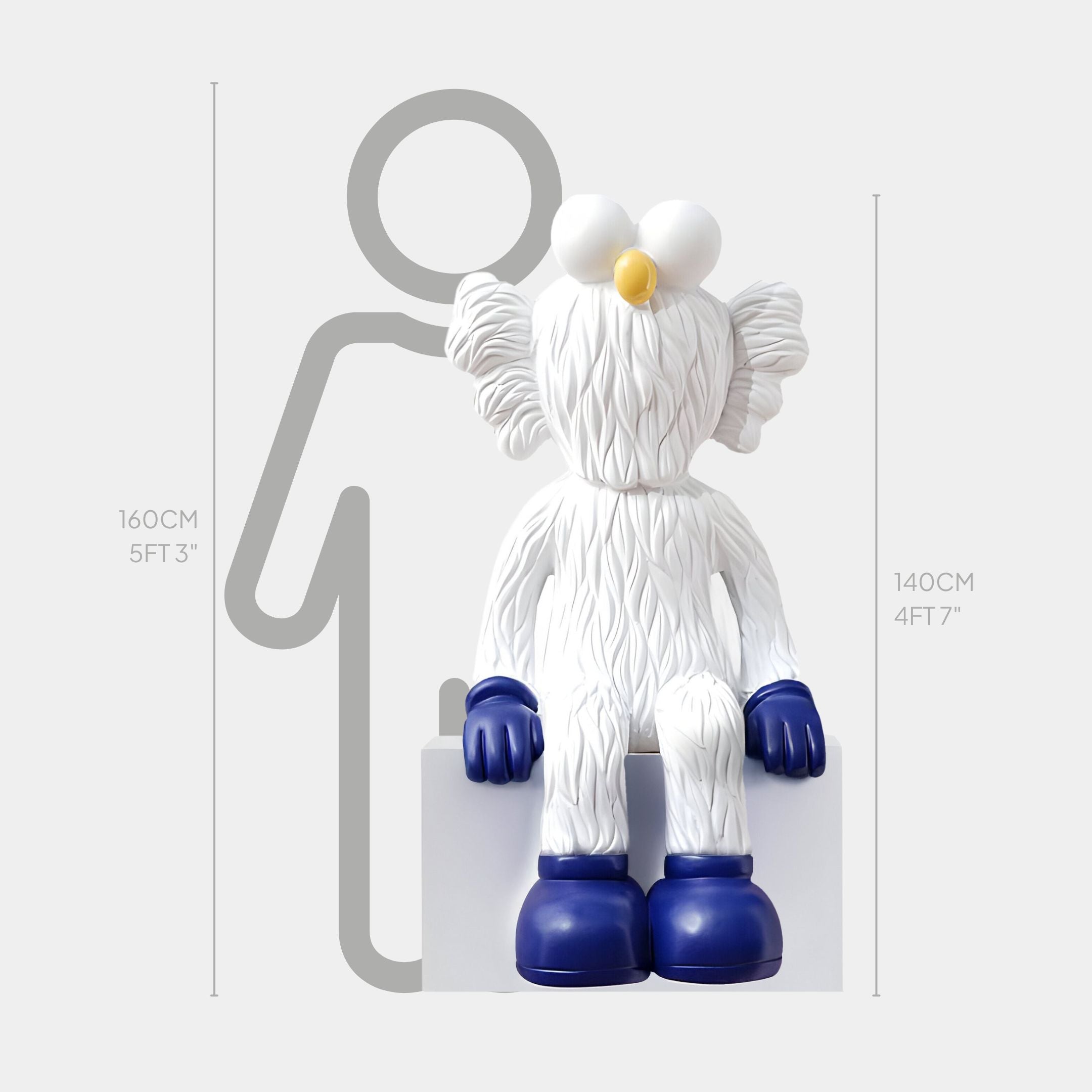 The Giant Sculptures White & Blue Iconify Furry Sitting Sculpture (140cm) features a cartoon figure with large eyes, yellow beak, blue gloves, and shoes sitting on a box; shown beside a height chart and human silhouette for scale.
