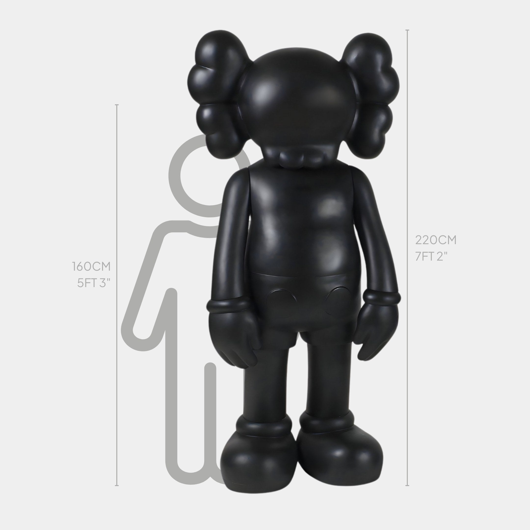 The Giant Sculptures Midnight Black Iconify Standing Sculpture, a large, cartoon-like figure with round ears, stands next to a height chart. Made of premium resin and measuring 220 cm (7 ft 2 in), it dwarfs the charts depicted person at 160 cm (5 ft 3 in).