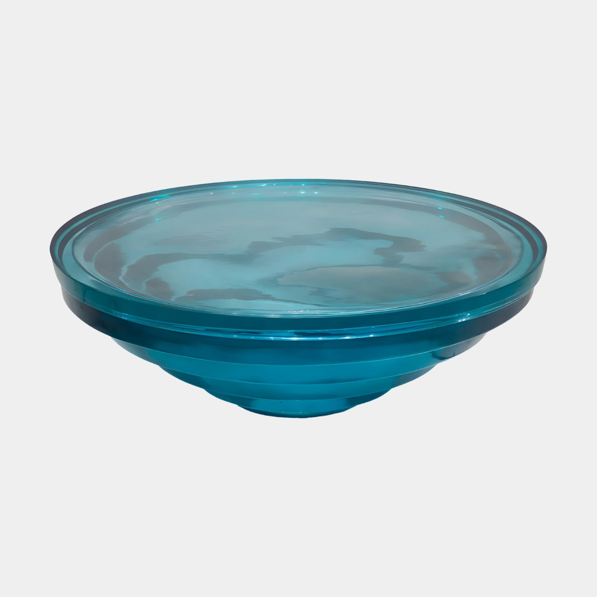 Teal Stepped Ring Hollow Cast Resin Low Table (105cm) in glossy translucent teal-blue with concentric stepped rings, shown on a plain white background.