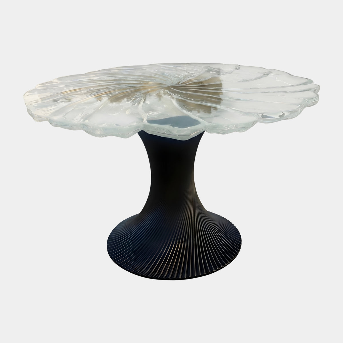 Clear Leaf Top Spiral Pedestal Round Dining Table (150cm) by Giant Sculptures, scalloped clear resin leaf-shaped top on a matt black ribbed pedestal base, shown against a plain white background.