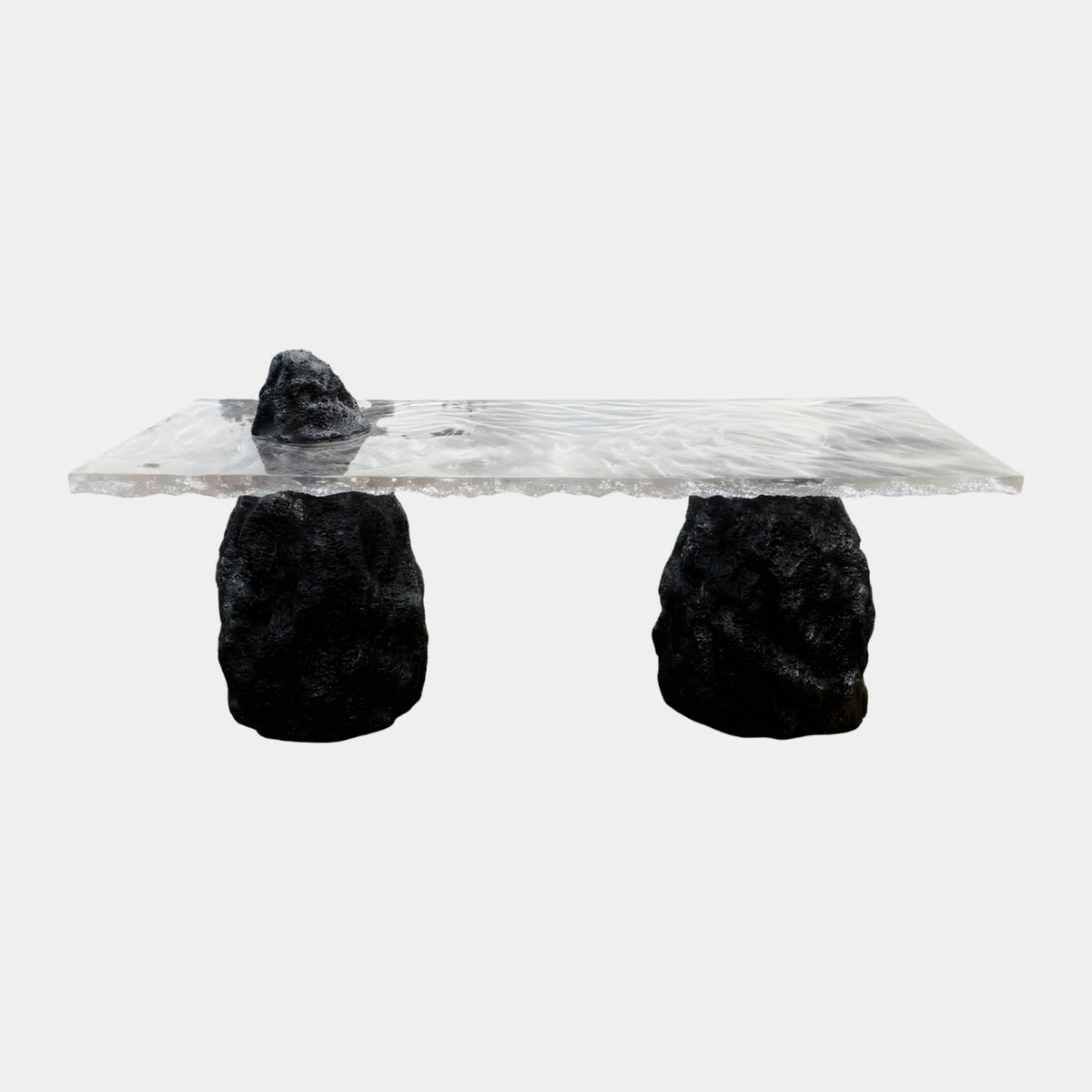 Clear Rippled Slab Black Rock Counter Table (210cm) by Giant Sculptures, a torn-edge resin slab resting on two rough black boulders with a smaller peak on top, shown on a plain white background.