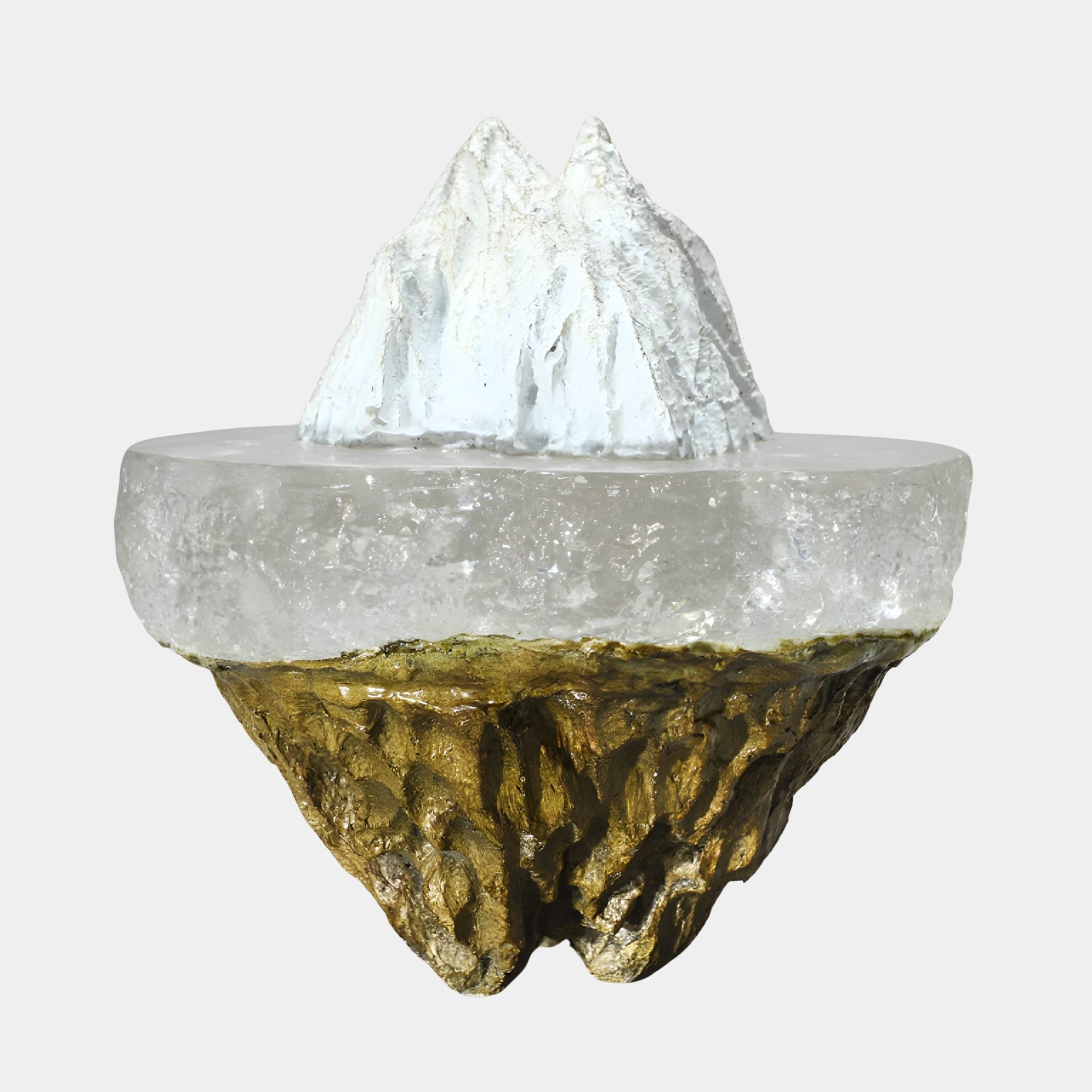Clear Resin Iceberg on Gold Textured Crater Sculpture by Giant Sculptures, with a frosted white peak above a clear icy layer and gilded base, on plain background.