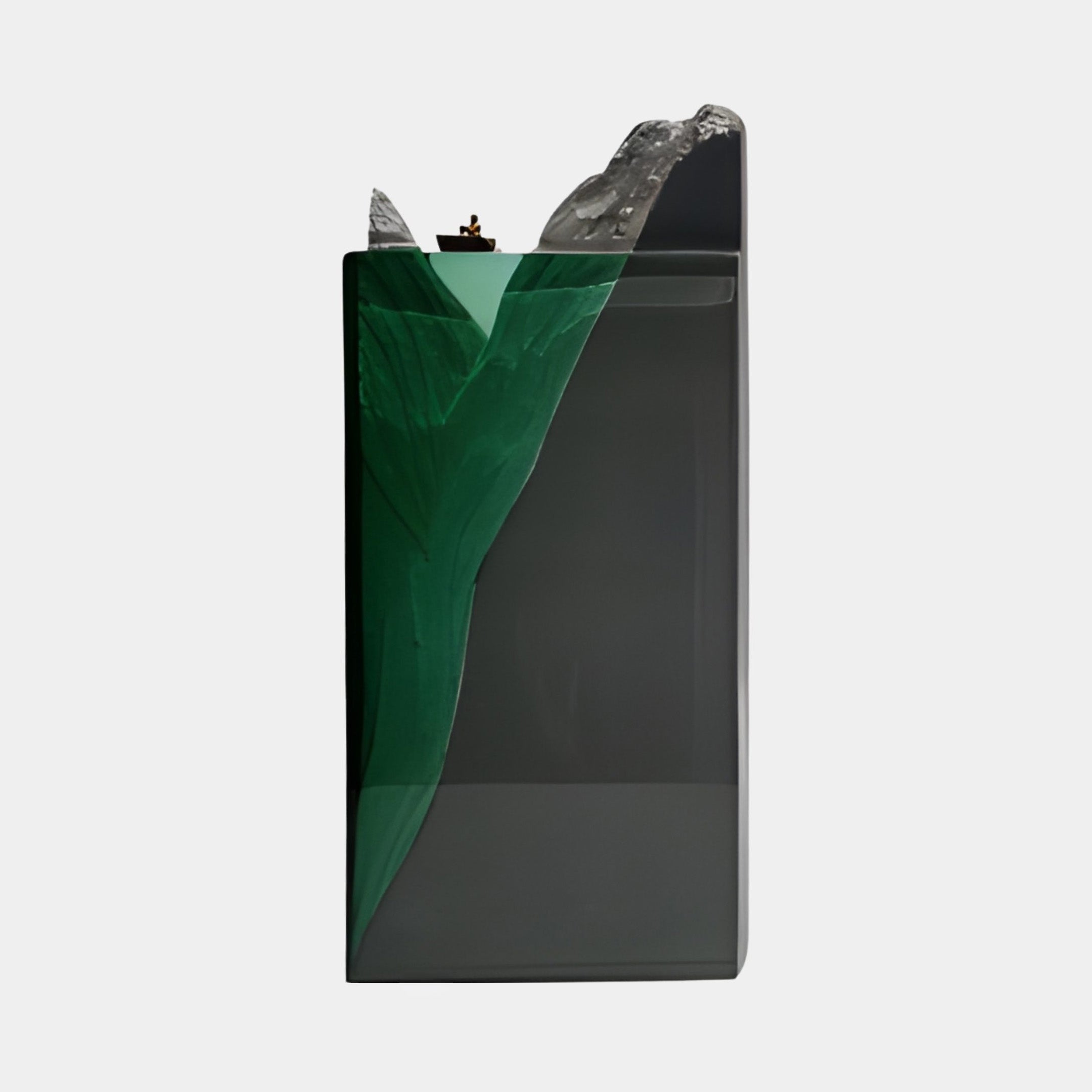Side view of Giant Sculptures' Deep Green Resin Submerged Peak & Bronze Boat Sculpture 40cm, showing the grey base and green resin peak with bronze boat.