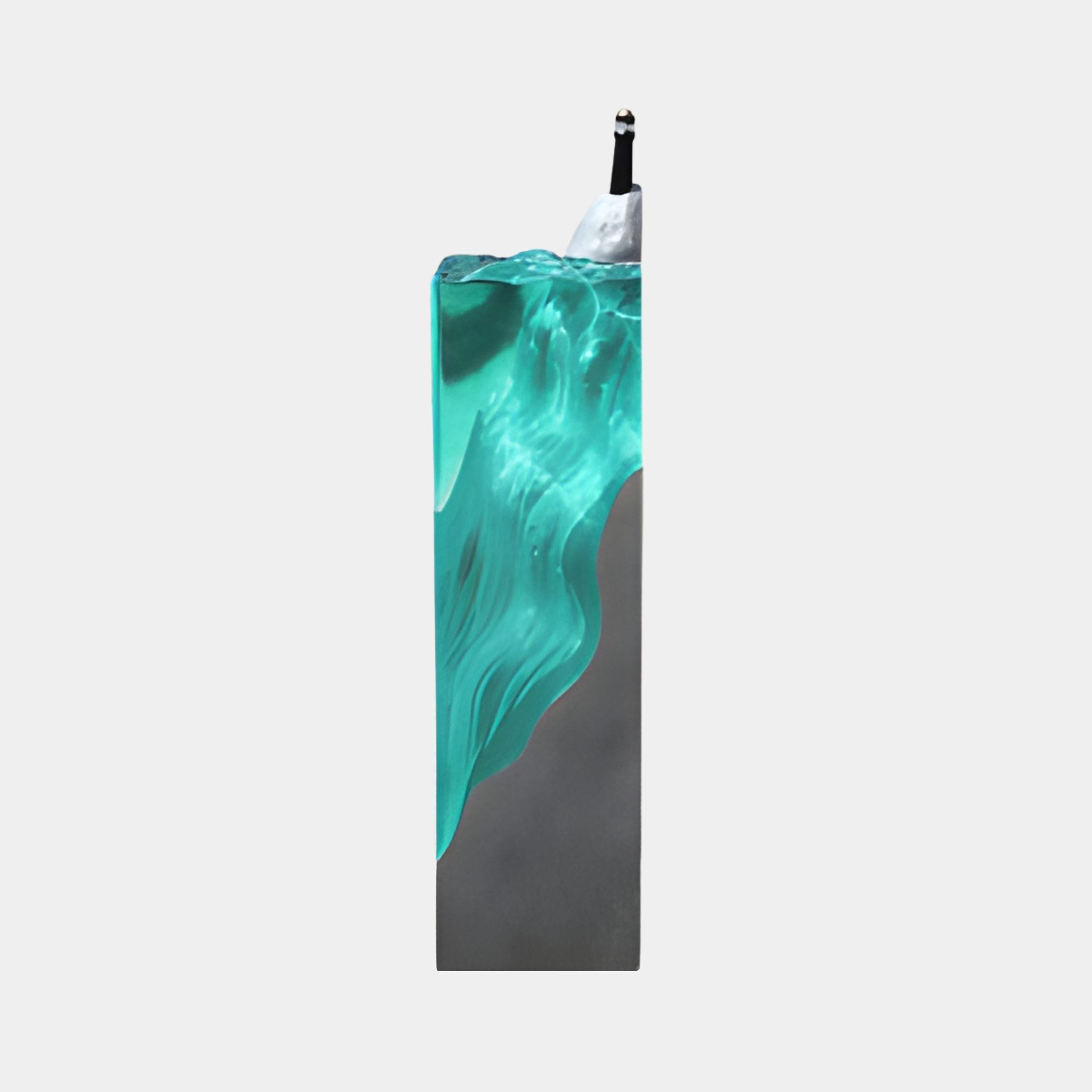 Giant Sculptures' 100cm Teal Translucent Wave Ocean Pillar resin sculpture, side view showing the glassy teal wave on a grey base with a small figure at the snowy summit, against a plain white background.