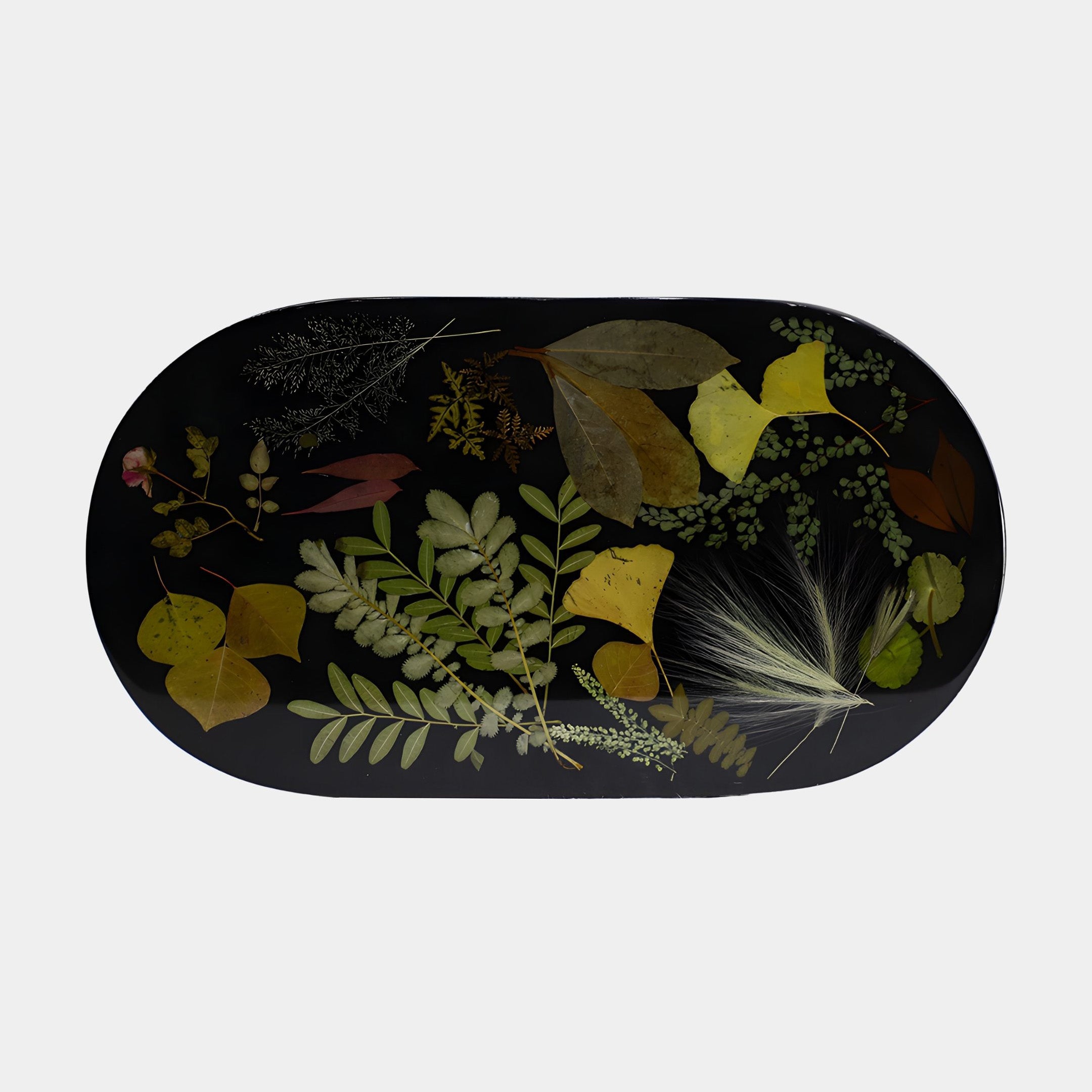 Giant Sculptures Black Botanical Leaf Inlay Resin Oval Tray 47cm, top view showing pressed green, yellow, and rust leaves and ferns set in glossy black resin.