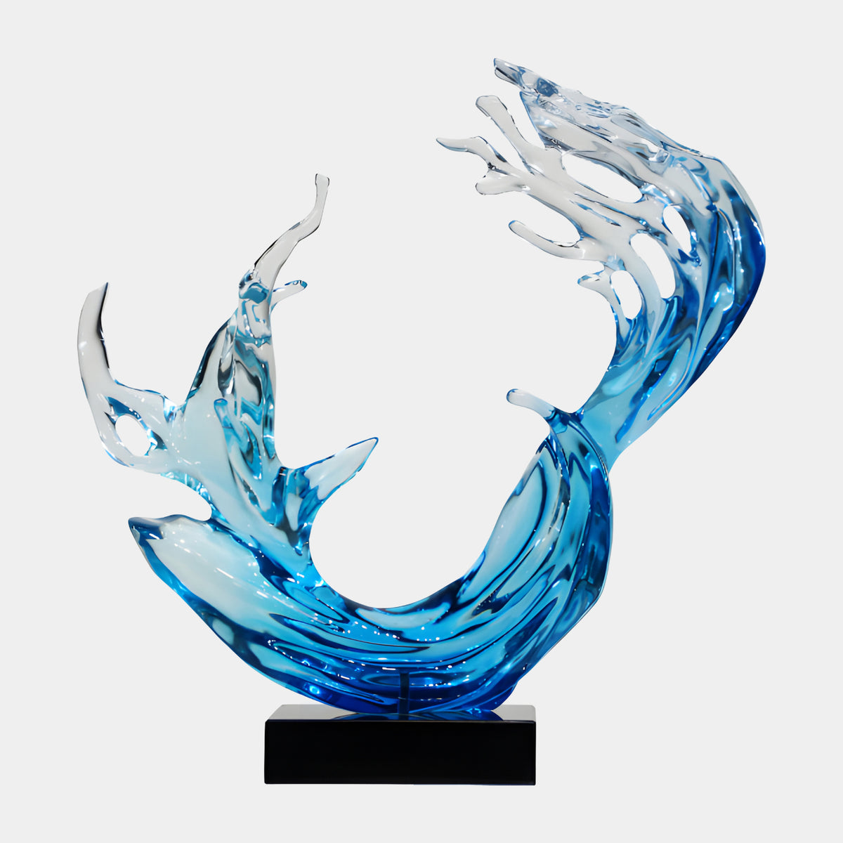 Blue Wave & Twin Fish Cast Resin Sculpture, 69cm, a curved blue-to-clear U-shaped wave with two fish rising inside, on a black base against a white background.