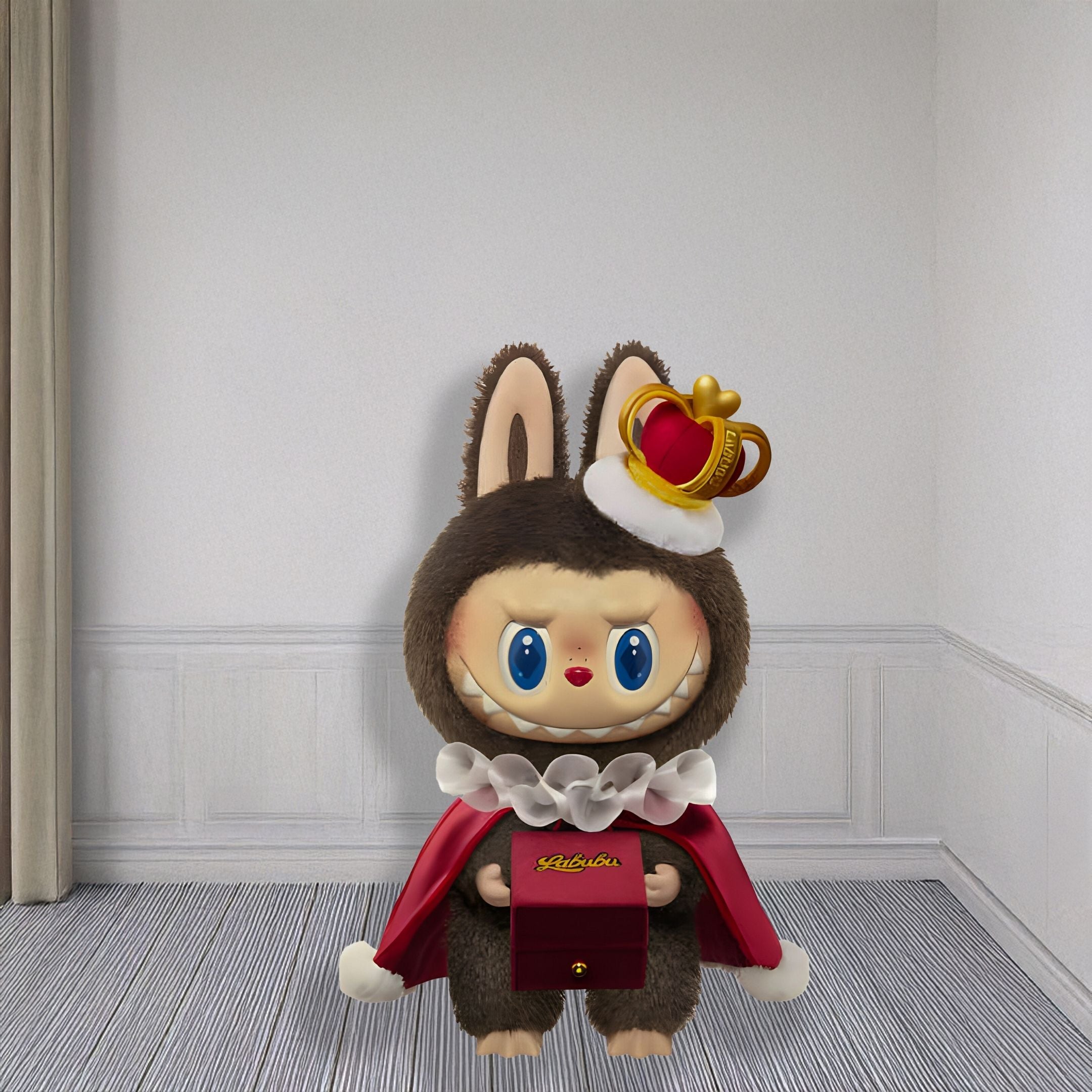 The Monster Lets Checkmate Box Labubu Sculpture - 100cm by Giant Sculptures features big blue eyes, a brown bunny costume with faux-fur hood, red cape, crown, and holds a red box with gold writing—Checkmate.