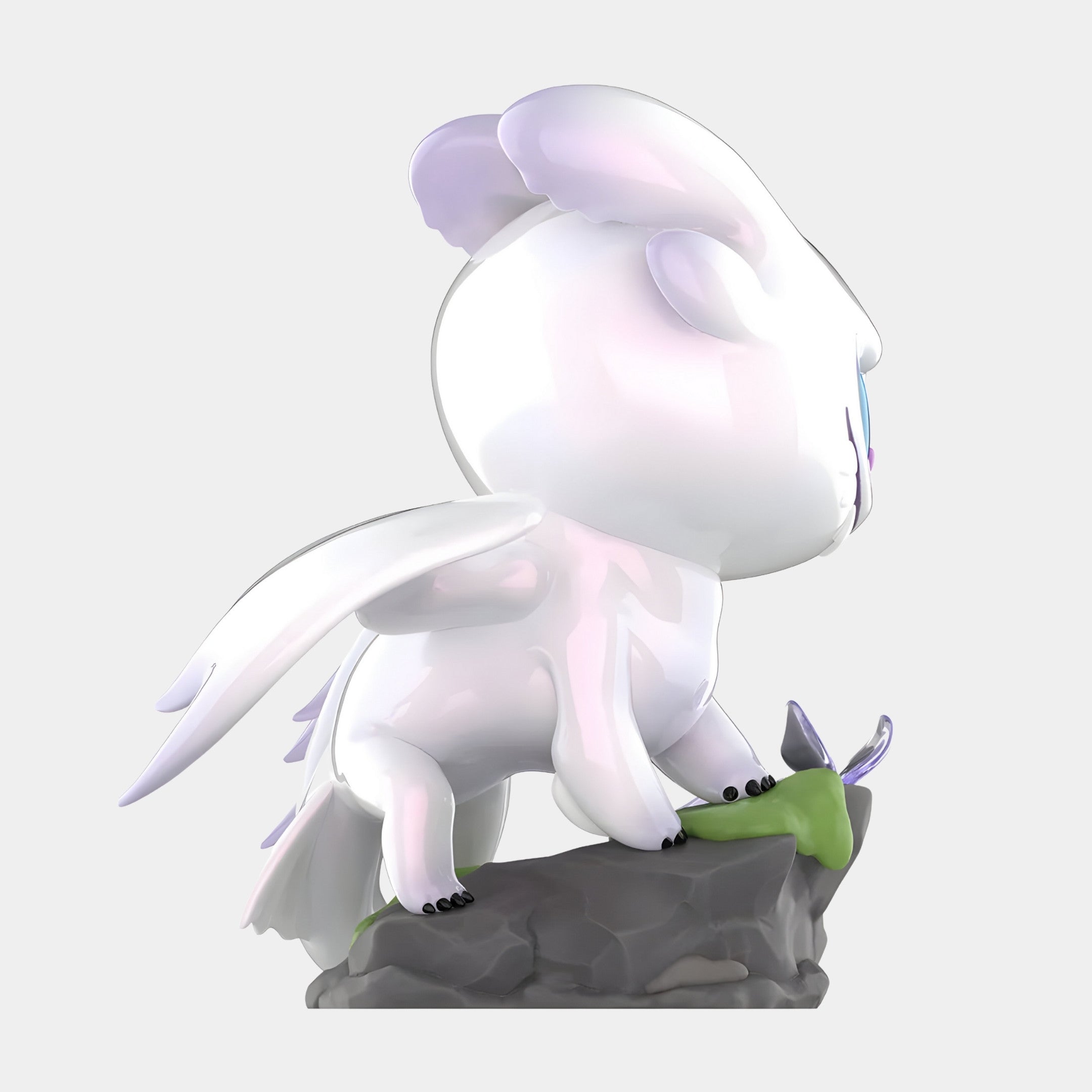The Dragon Bond Light Fury Labubu Sculpture - 100cm by Giant Sculptures features a glossy, cartoon-like dragon with wings and blue eyes, standing playfully on a mossy gray rock. Made of smooth fibreglass, it faces right with a stylized design.