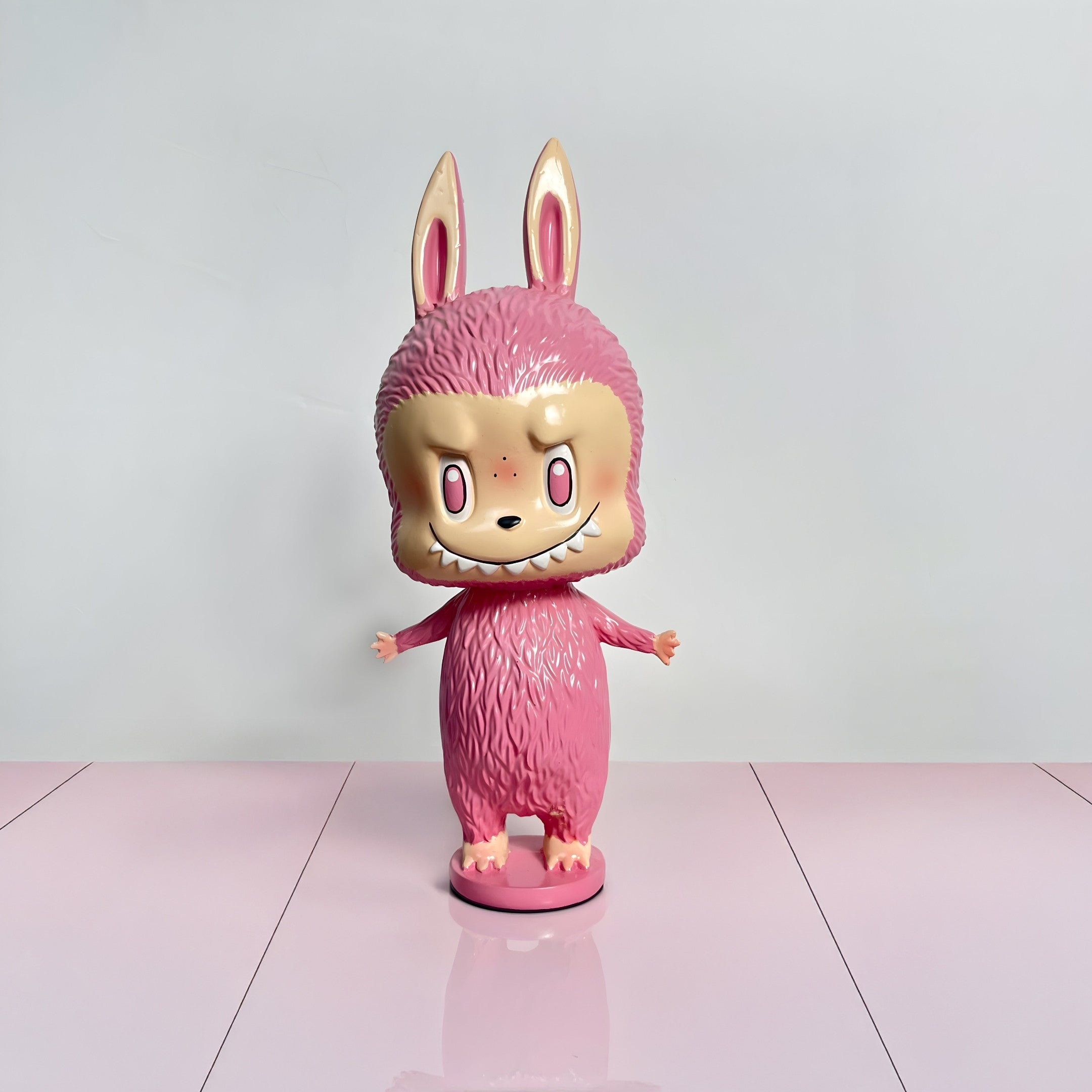 The Little Monster Pink Labubu Sculpture - 100cm by Giant Sculptures features bunny ears, big eyes, and a mischievous grin on a matching pink base—ideal as playful interior décor against pale backgrounds and floors.