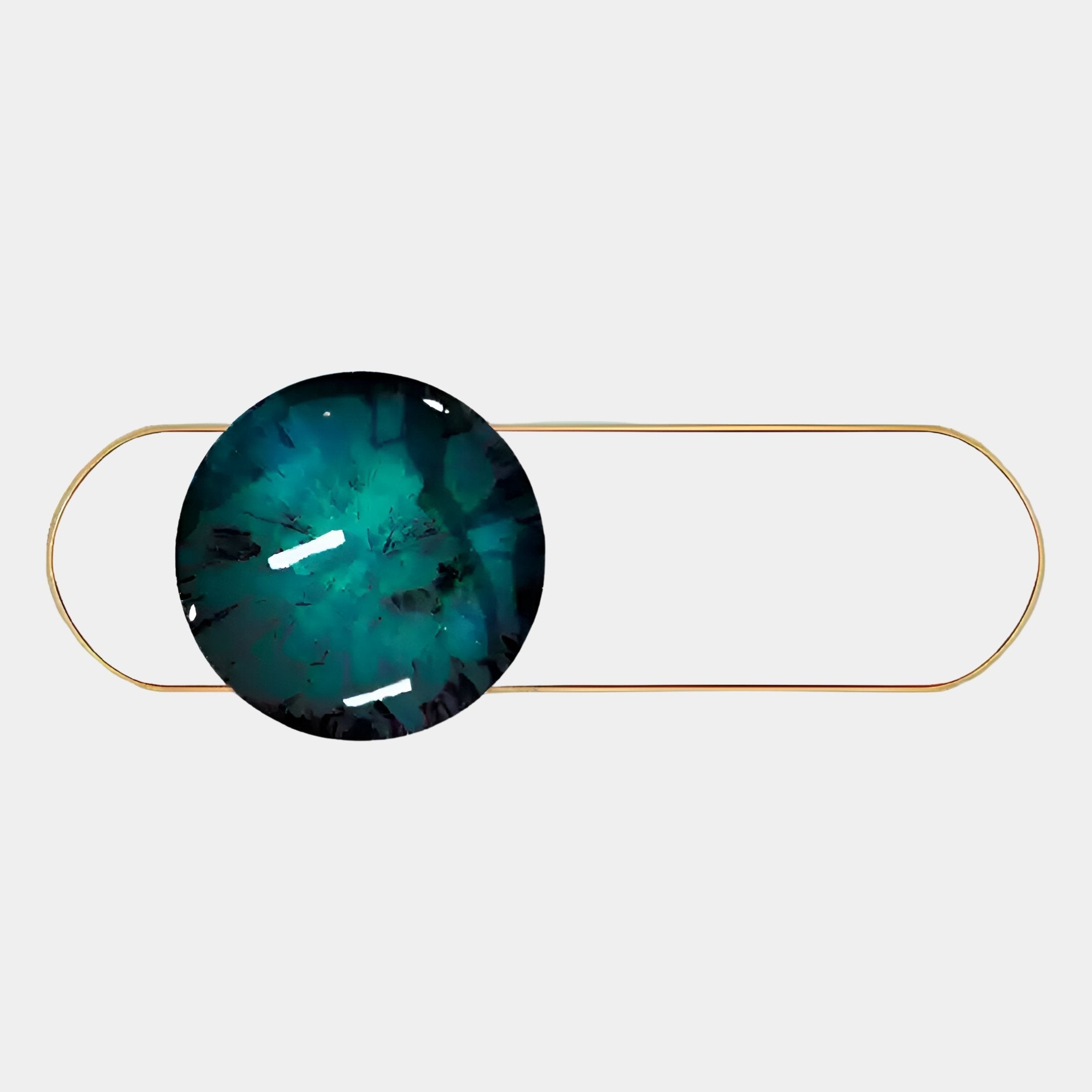 A gold oval paperclip with a large, round, teal and black marbled stone—evoking the Vitreon 3D Deep Teal Crystal Porcelain With Gold Accent Wall Art by Giant Sculptures—displayed on a plain white background.