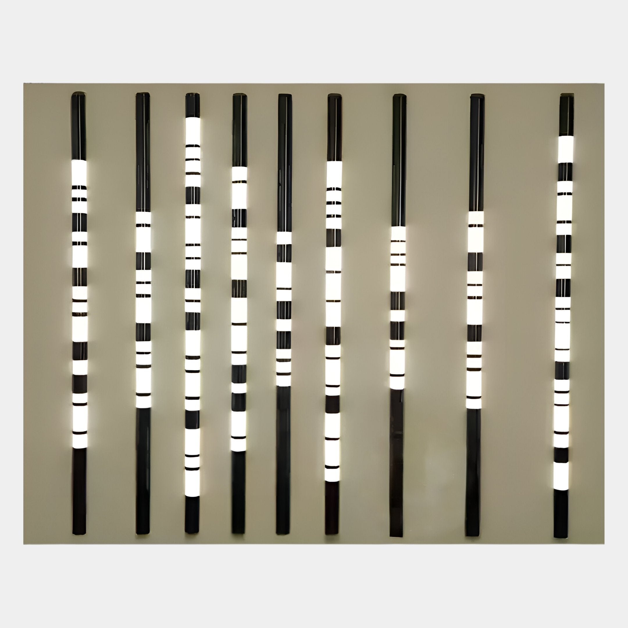 Eight vertical black rods with illuminated white and black stripes are evenly spaced on a plain, light background, forming the Strata Slate LED Wall Art by Giant Sculptures—a geometric piece reflecting sleek, contemporary design.