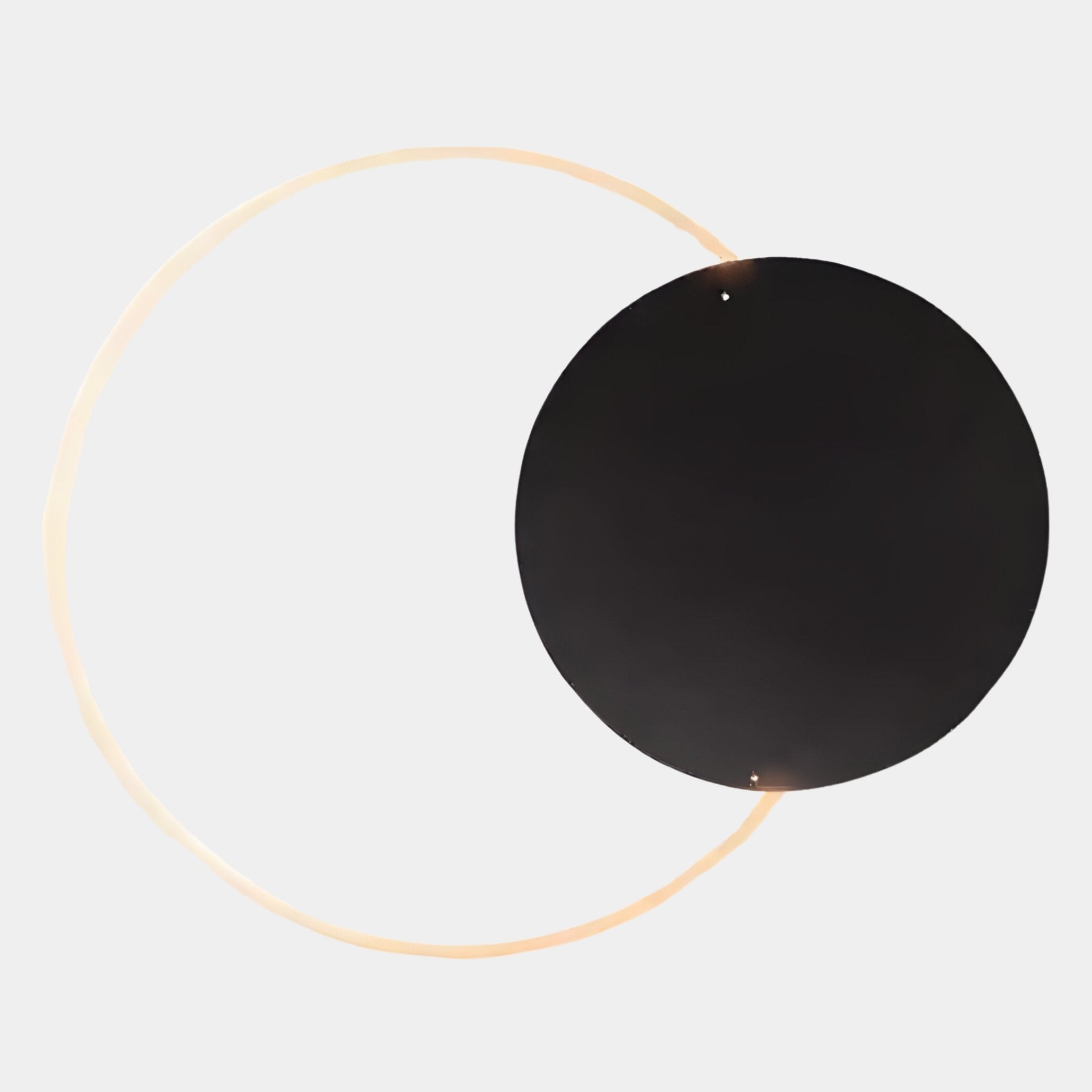 The Soluna Onyx Acrylic 3D LED Wall Art by Giant Sculptures features a large black acrylic circle overlapping a thin, glowing golden ring on a plain white background, creating minimalist and abstract décor.