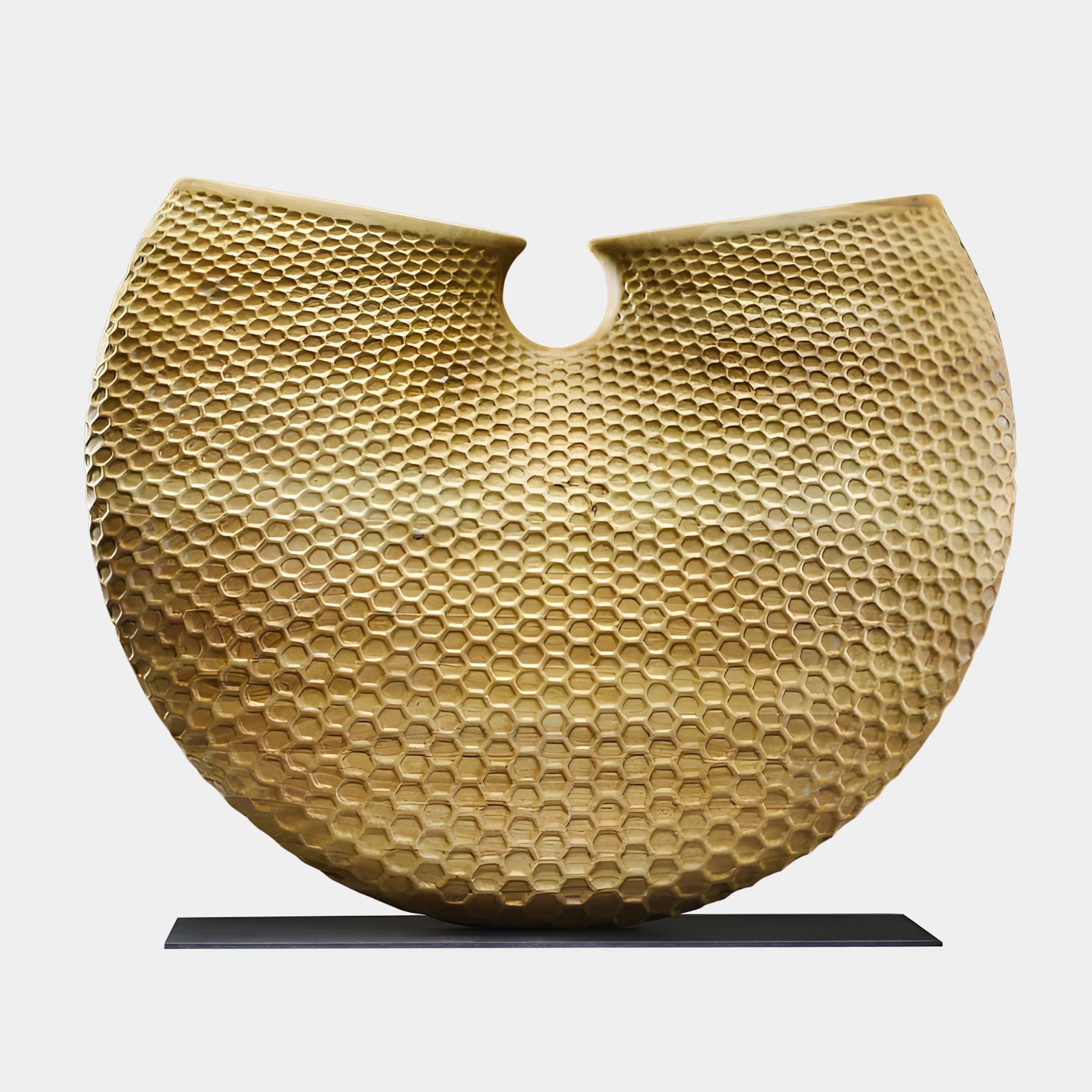 Honeycomb Disc Gold Abstract Wood Sculpture by Giant Sculptures, a 100cm crescent form with hand-carved hexagonal texture on a black base, shown on white.