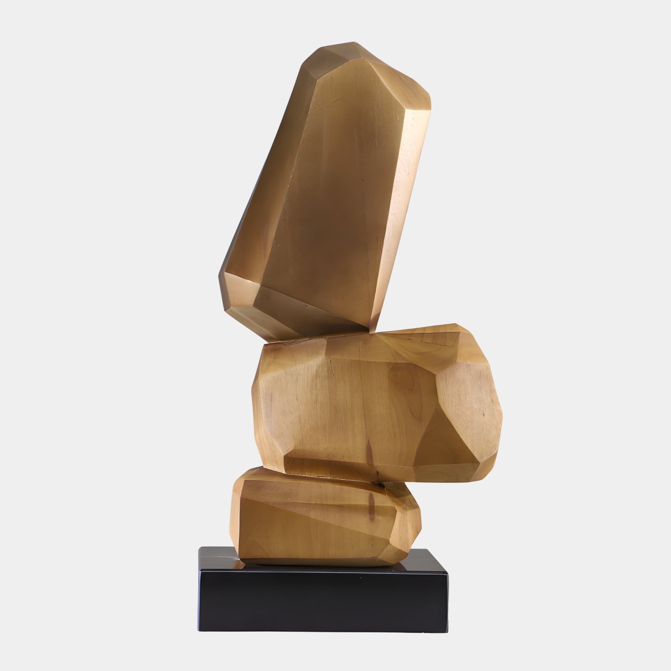 Stack Gold Boulder Abstract Wood Sculpture by Giant Sculptures, three faceted gold-champagne boulders balanced on a black plinth against a plain background.