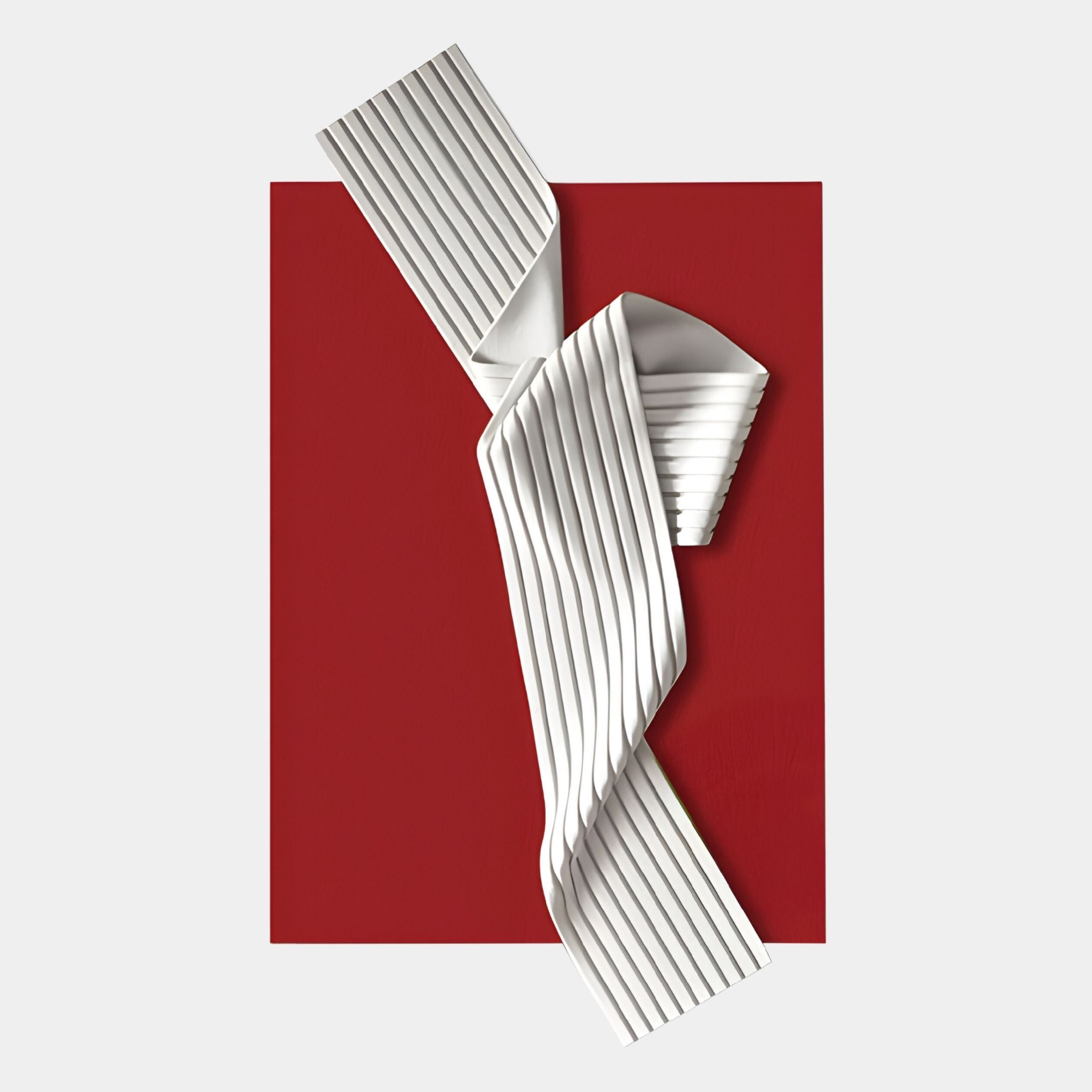 The Arcluma Crimson Folded Ribbon Leather 3D Wall Art by Giant Sculptures features folded white leather diagonally over a bold red background, creating striking minimalist wall decor on a light grey surface.