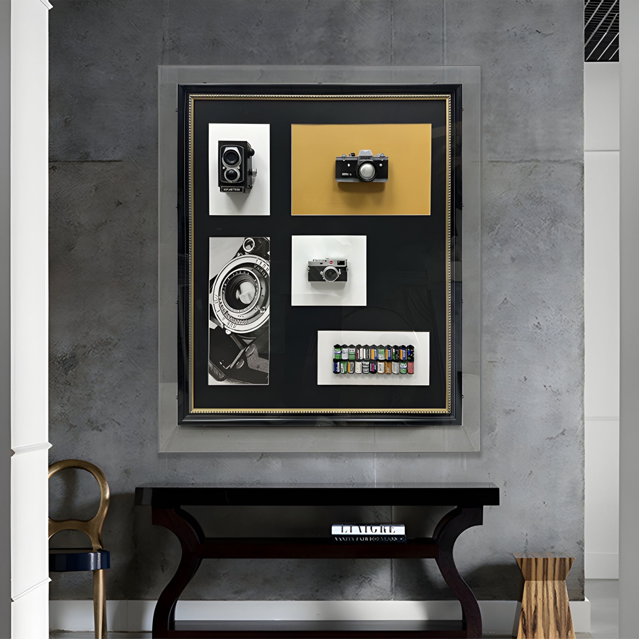 The Fotera Vintage Camera Acrylic Box 3D Wall Art by Giant Sculptures displays cameras, film canisters, and camera artwork in a grid on a gray wall above a black console table with decorative accents.