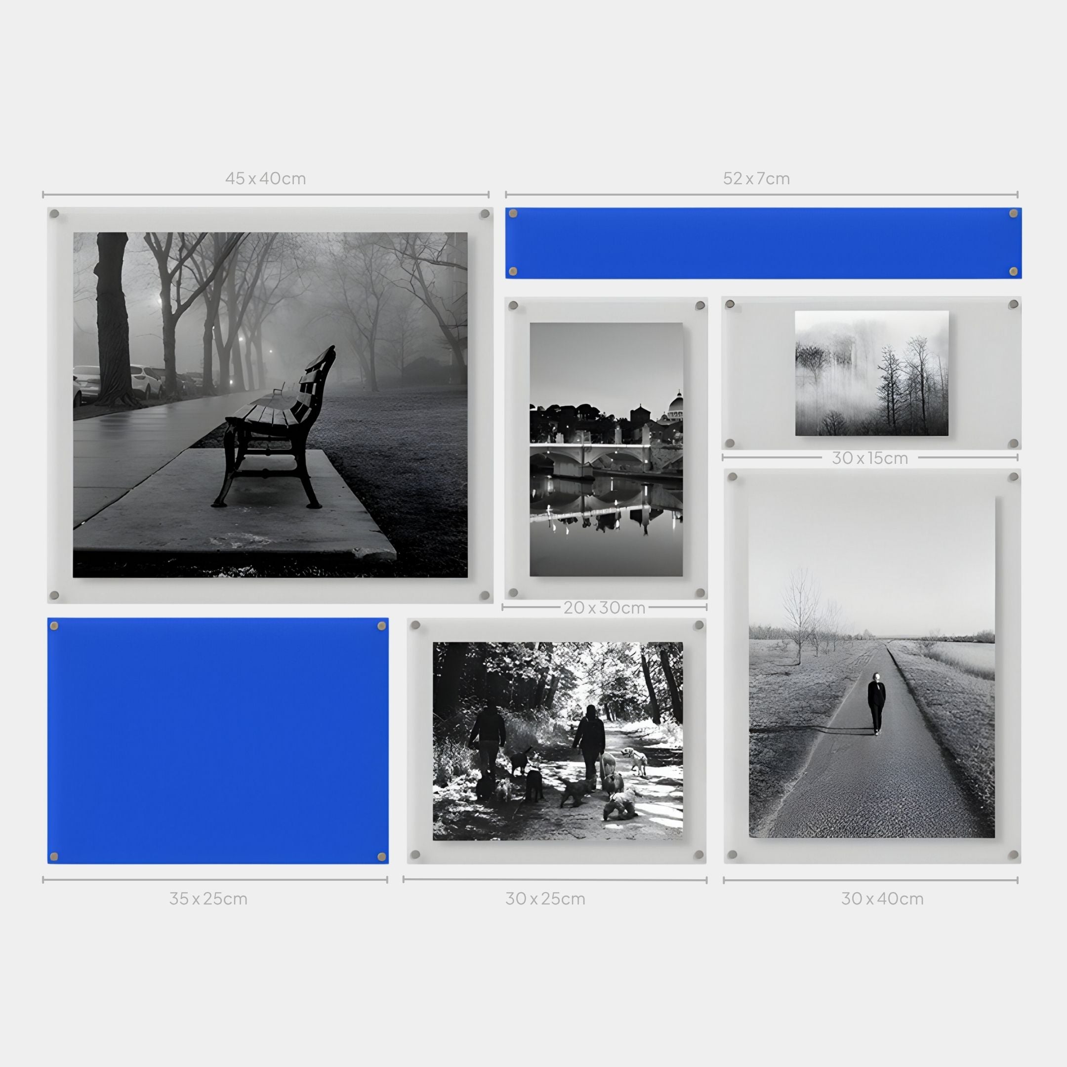 A modern display showcases the Giant Sculptures Framegrid Blue Mixed-Size Gallery 7-Set Acrylic Wall Art, featuring seven minimalist frames—some with black-and-white outdoor photos, others in bold blue—each labeled with its centimeter size.