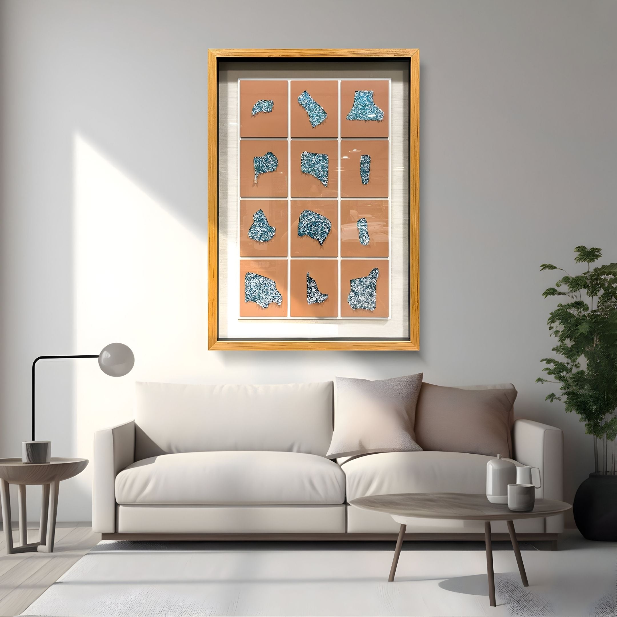 A modern living room with a white sofa, round coffee table, floor lamp, potted plant, and the Agliera Aqua Crystal Shard Grid Framed 3D Wall Art by Giant Sculptures featuring blue shapes on an orange background displayed on the wall.