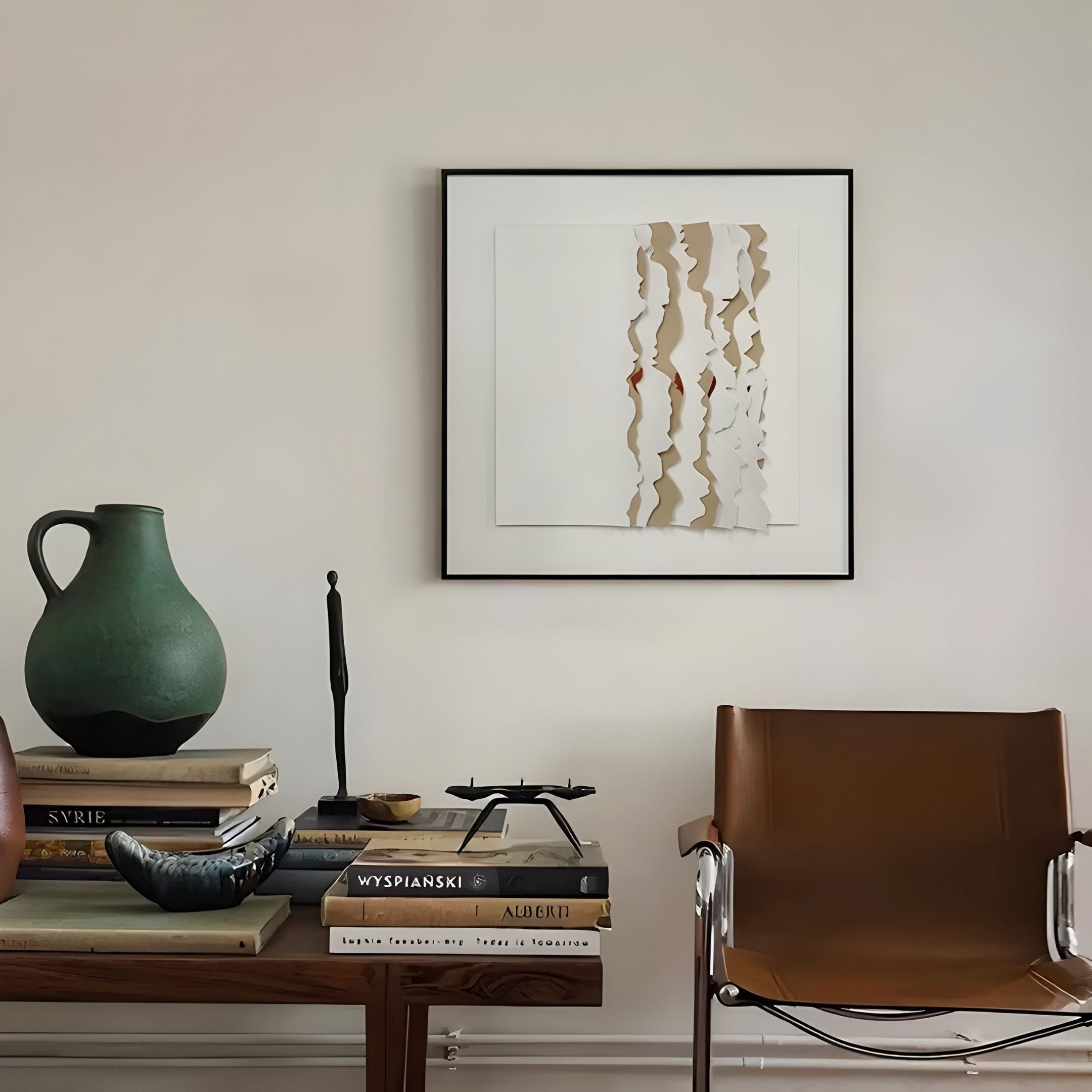 A minimalist interior features a brown leather chair, wooden table with books, green ceramic pitcher, black sculpture, and the Rivura White Layered Sandstone Texture 3D Wall Art by Giant Sculptures.